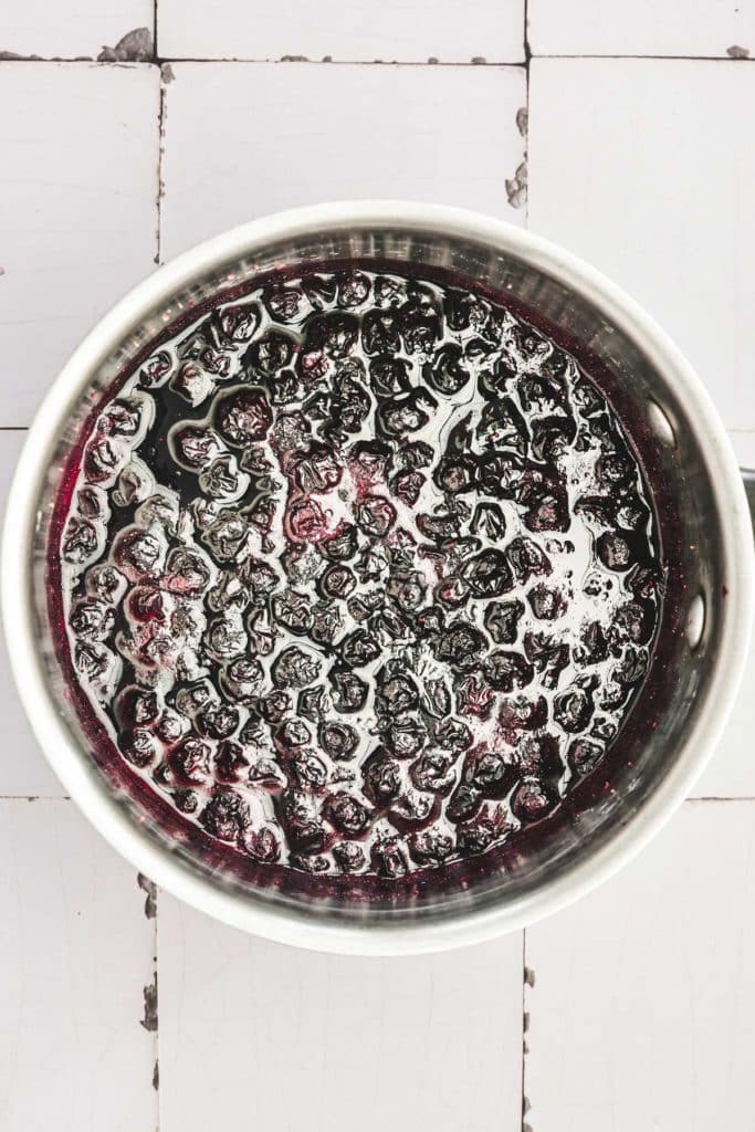 saucepan with simmering blueberry compote mixture