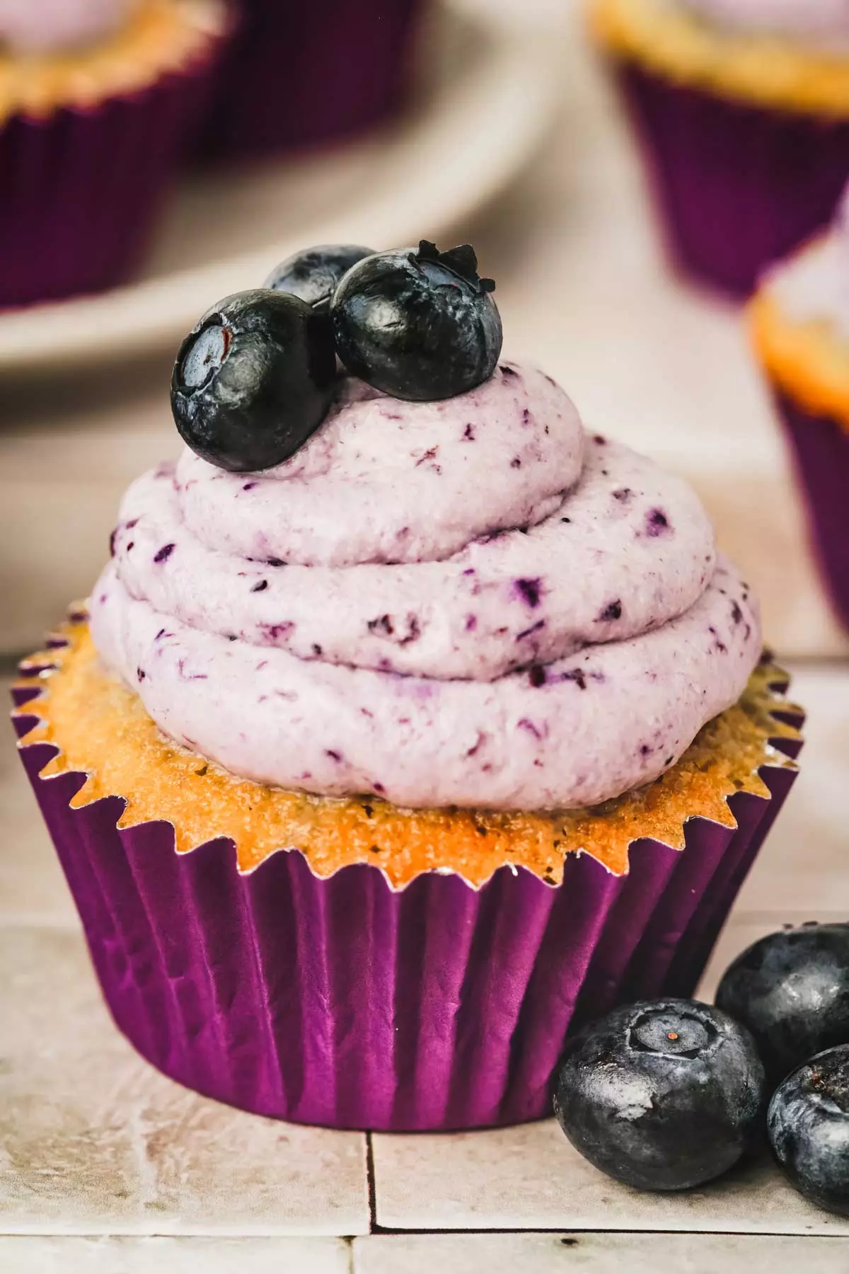 Cupcake avec un glaçage myrtille et des myrtilles frâiches.