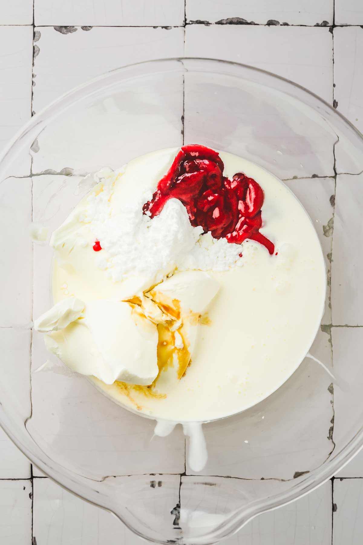 large mixing bowl with raspberry frosting ingredients