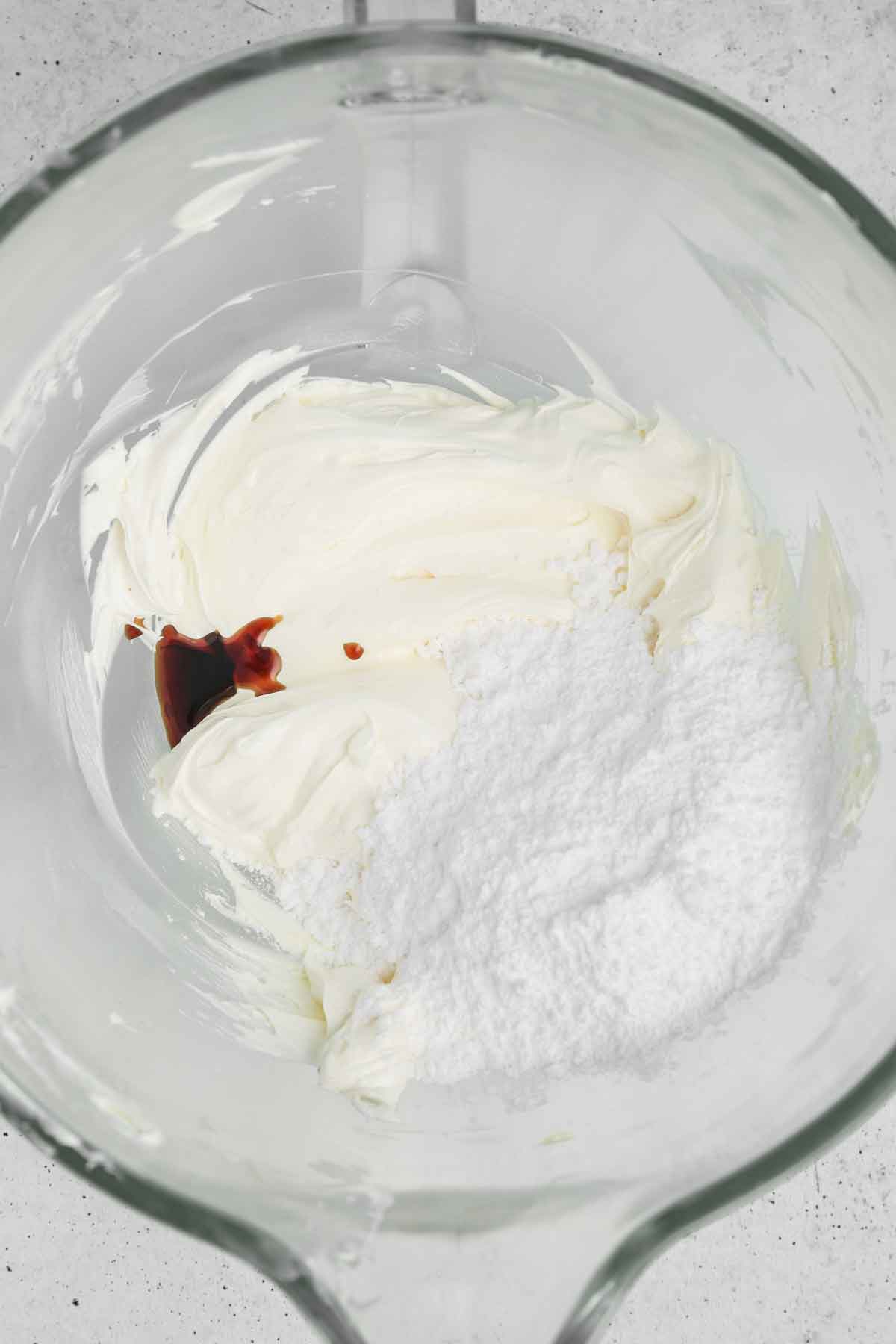 large bowl with whipped butter, vanilla extract and powdered sugar