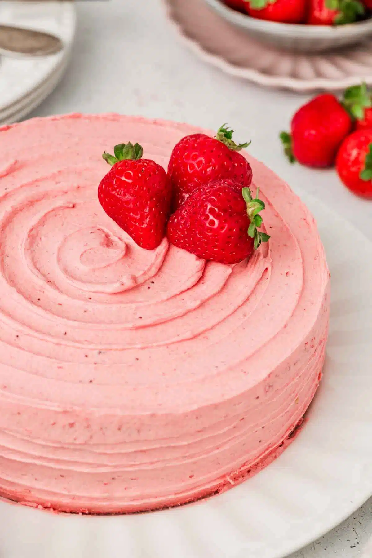 strawberry cake frosed with strawberry buttercream on a plate
