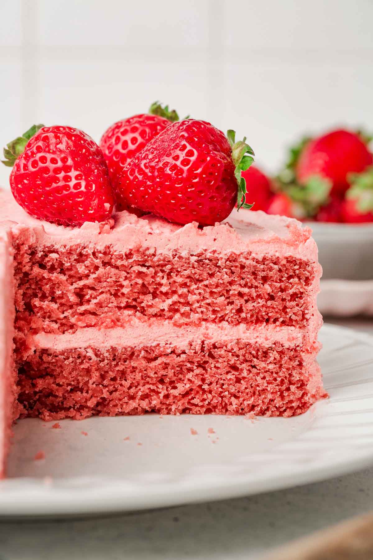 gâteau rose coupés avec des fraises entières
