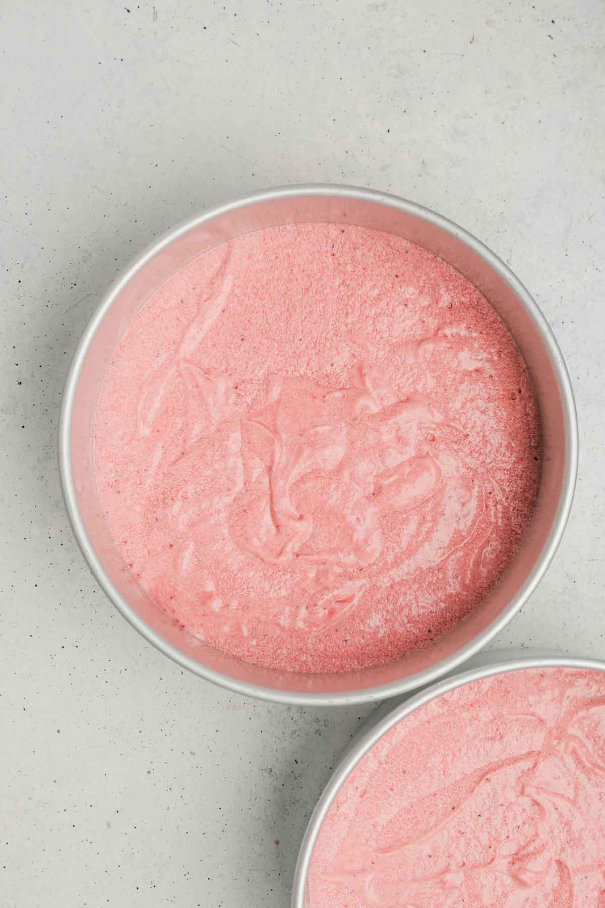 moule à gâteau avec de la pâte à gâteau rose