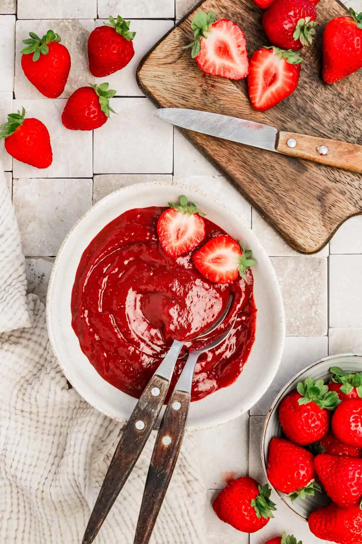bol avec de la purée de fraises et fraises coupés