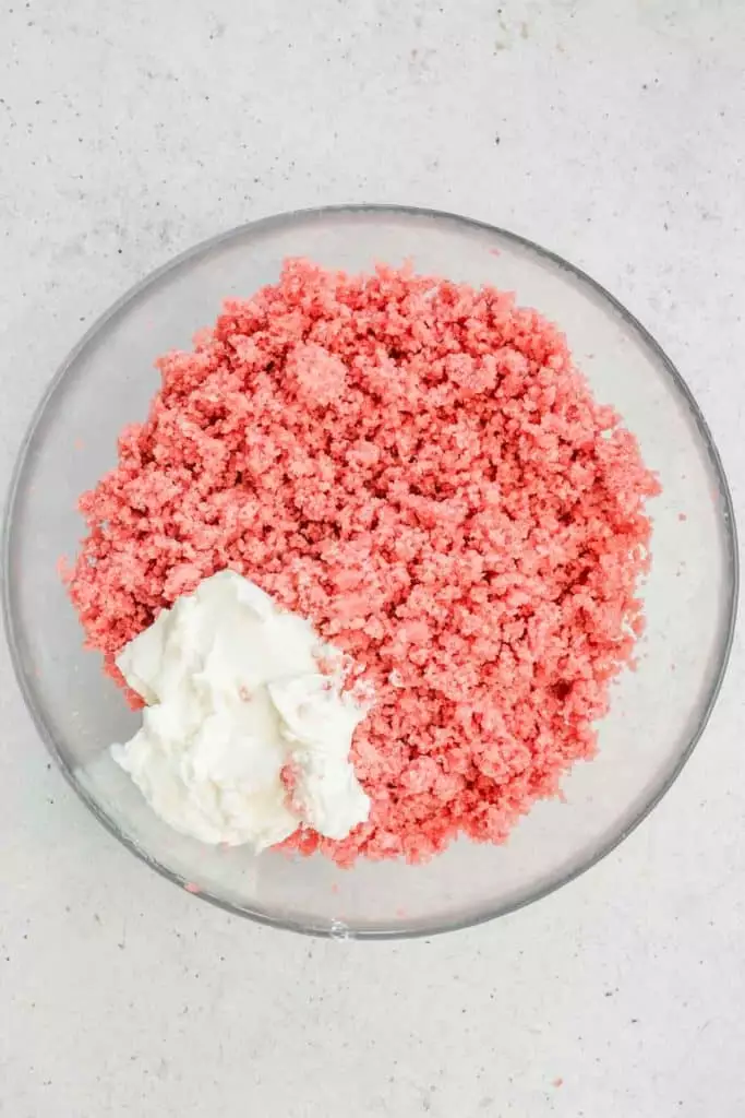 bol avec des miettes de gâteau rose et du fromage frais