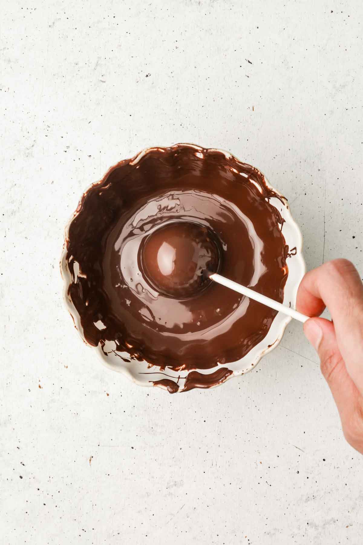 bol avec du chocolat fondu et un cake pop au chocolat dedans