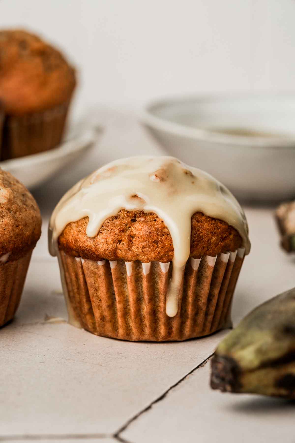 Soft pumpkin banana muffin topped with vanilla maple glaze