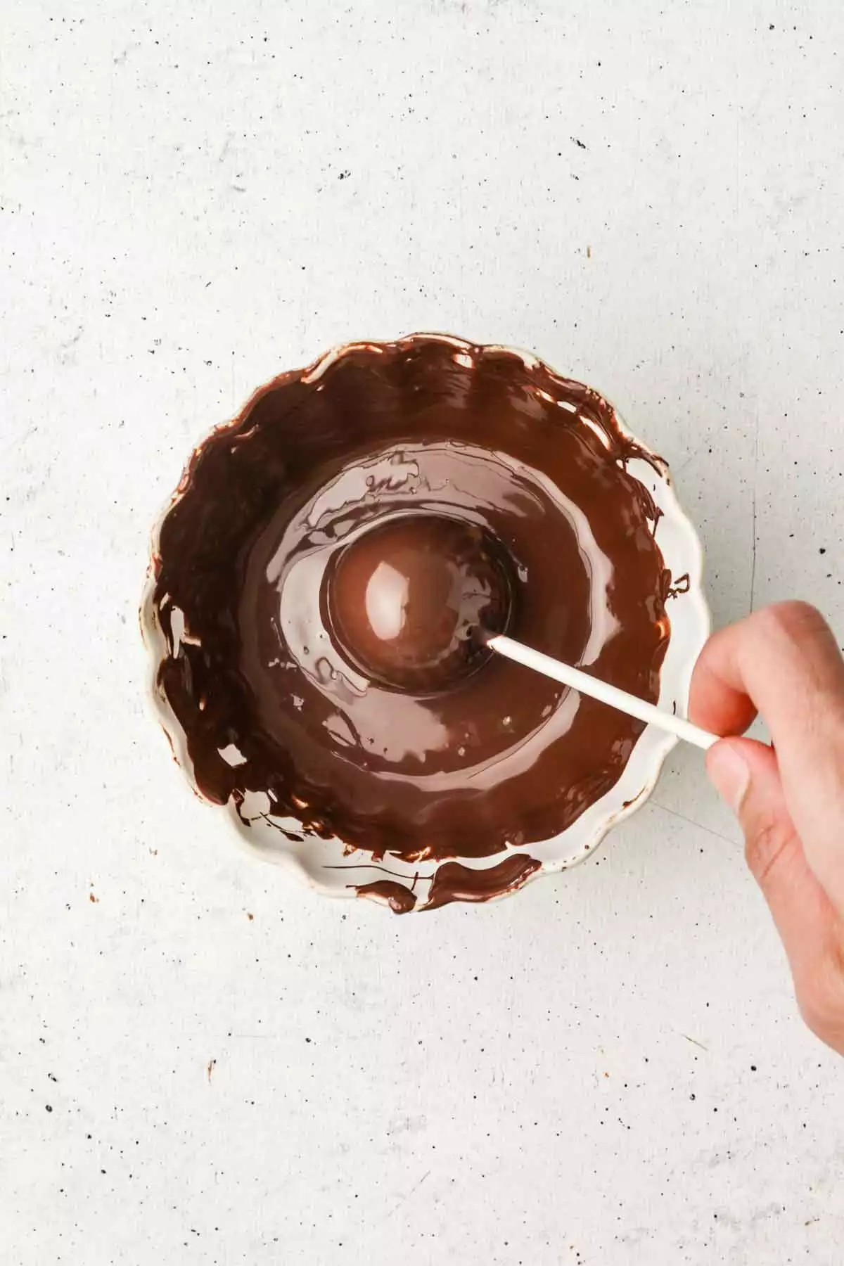 bol avec du chocolat fondu et un cake pop au chocolat dedans