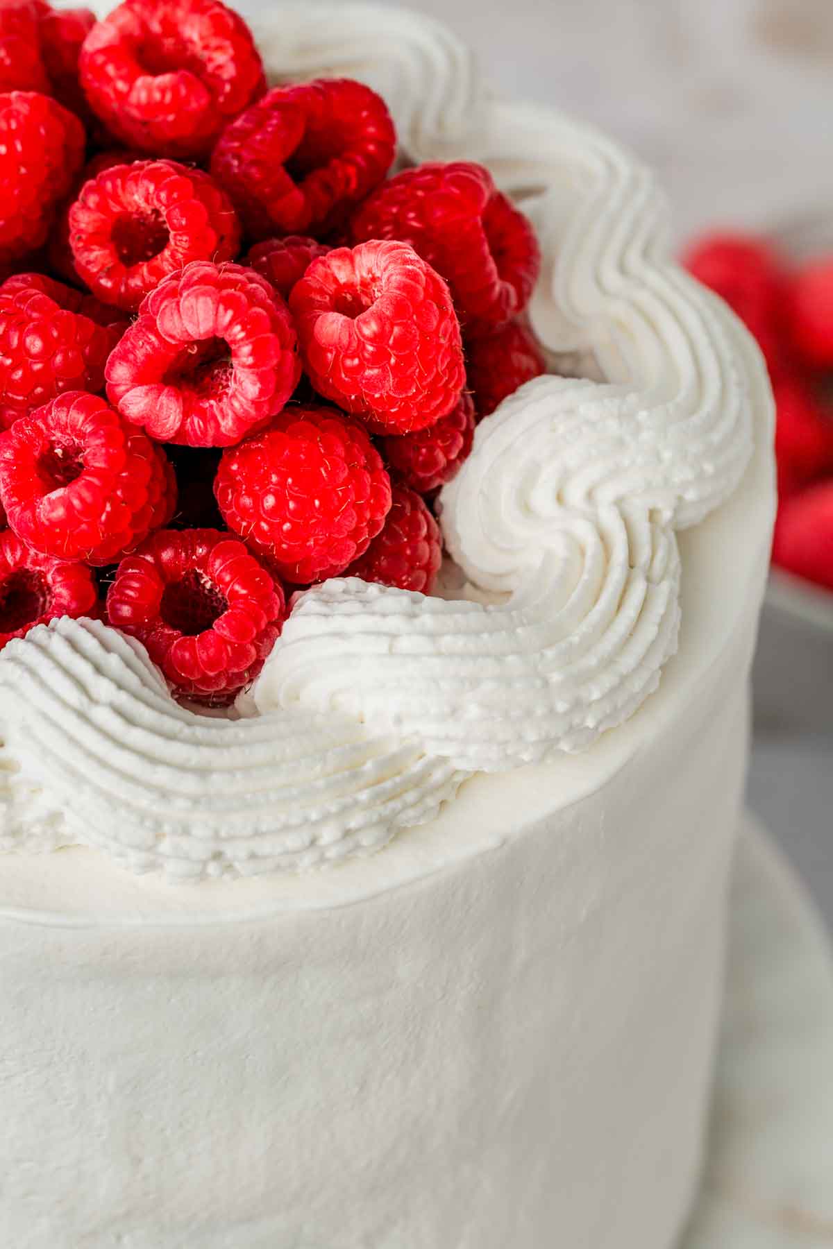 chantilly sur un gâteau avec des framboises