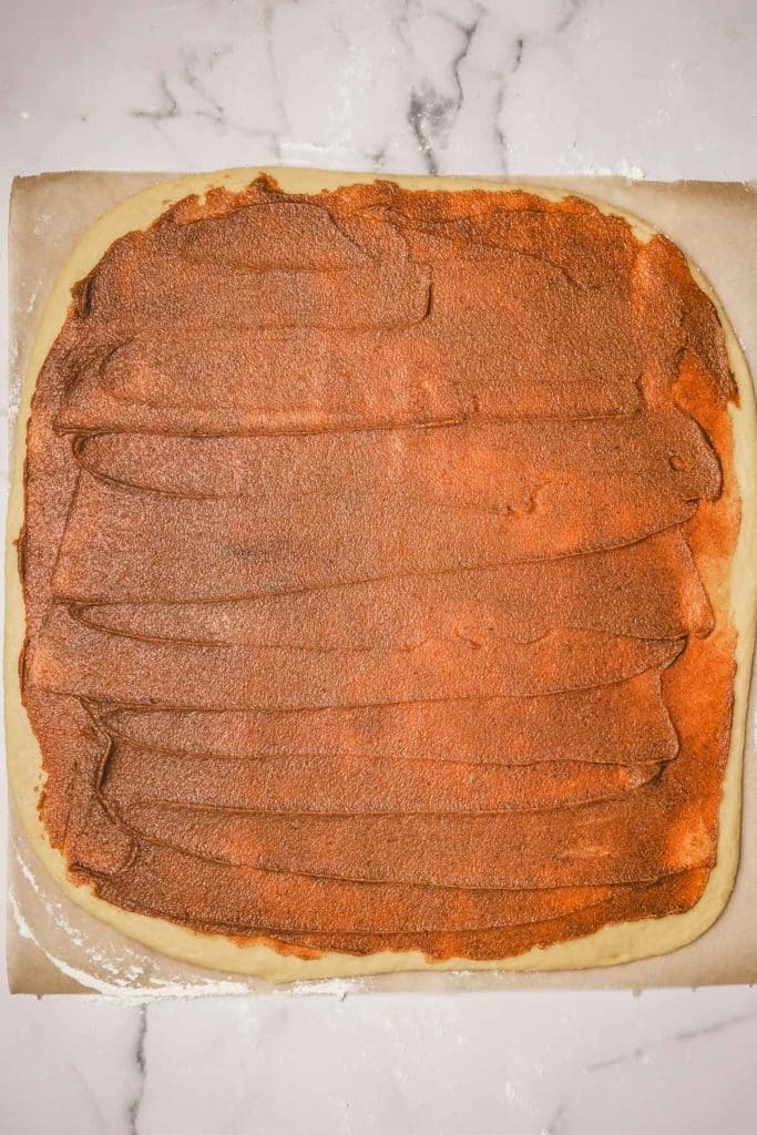 rolled out dough with cinnamon sugar and caramel filling