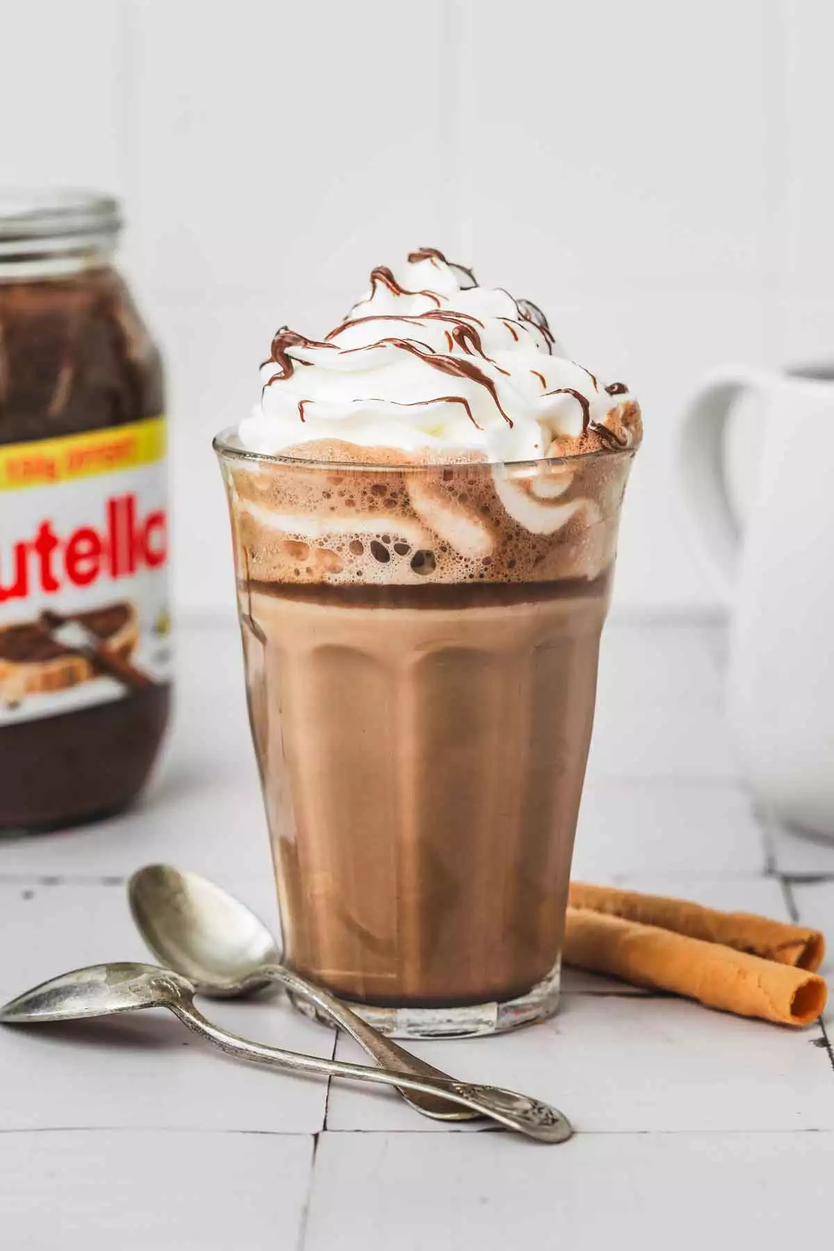 verre avec un latte au nutella sur une table avec de la chantilly