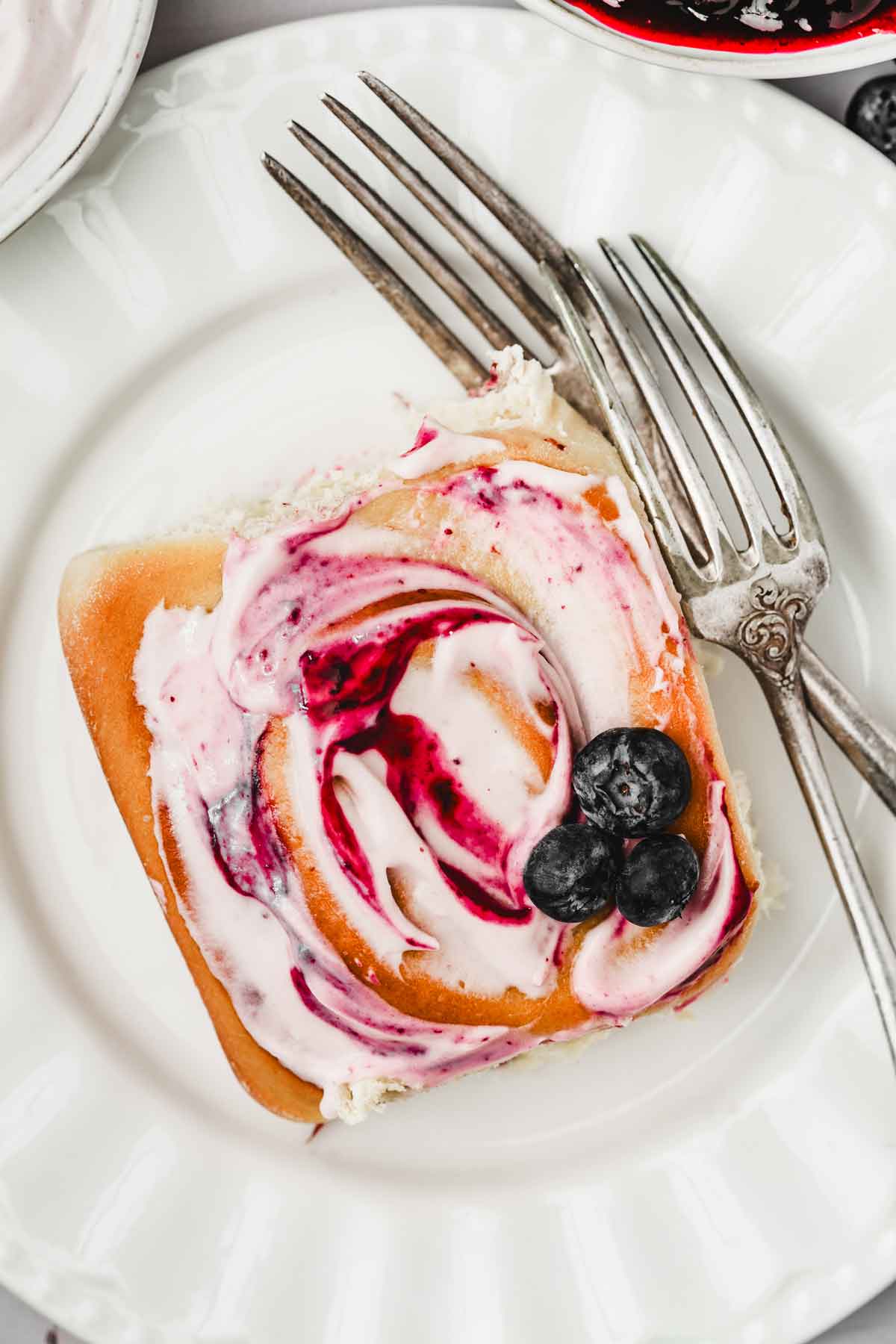 plate with a blueberry sweet roll