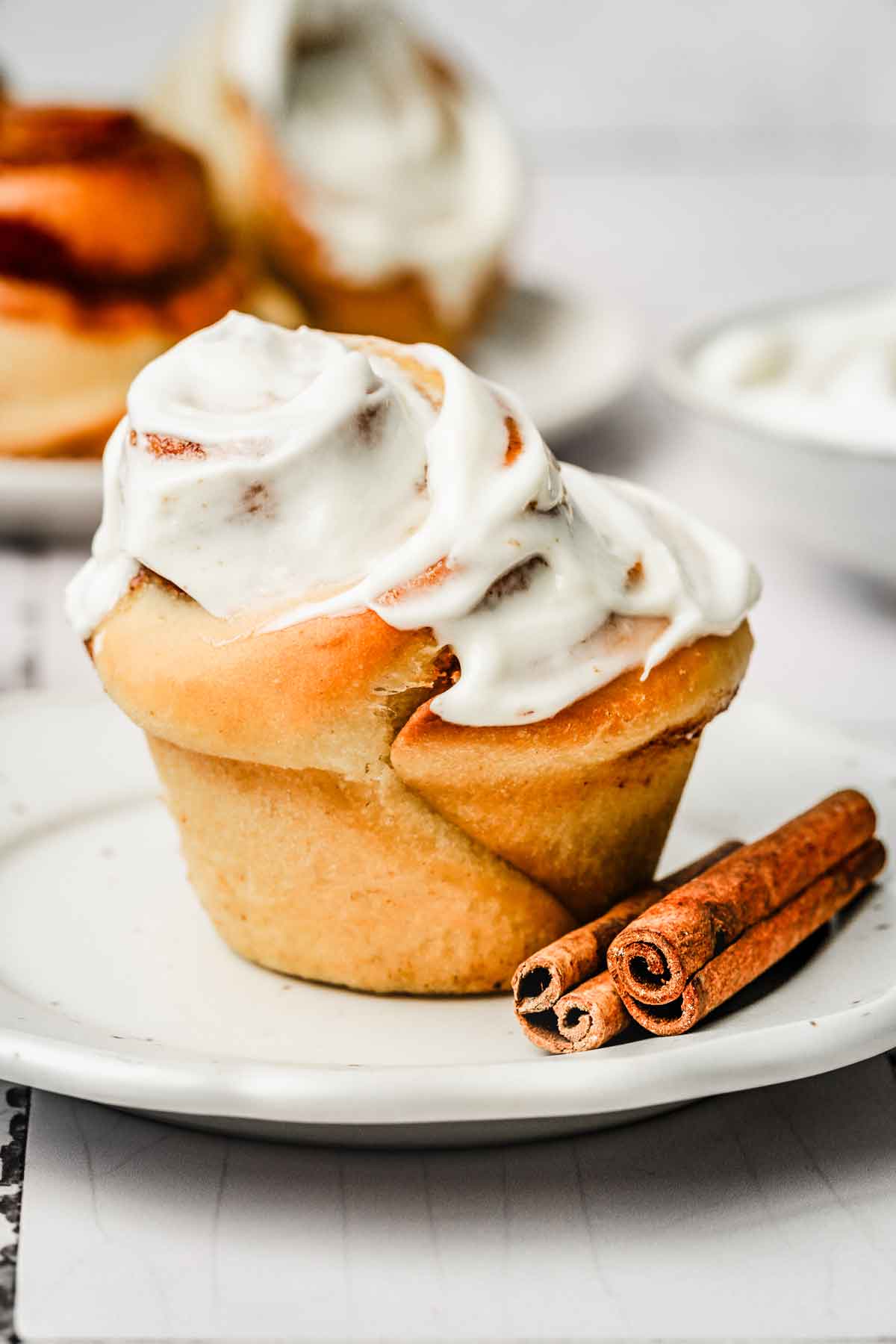 cinnamon roll muffin with a cream cheese glaze on a plate
