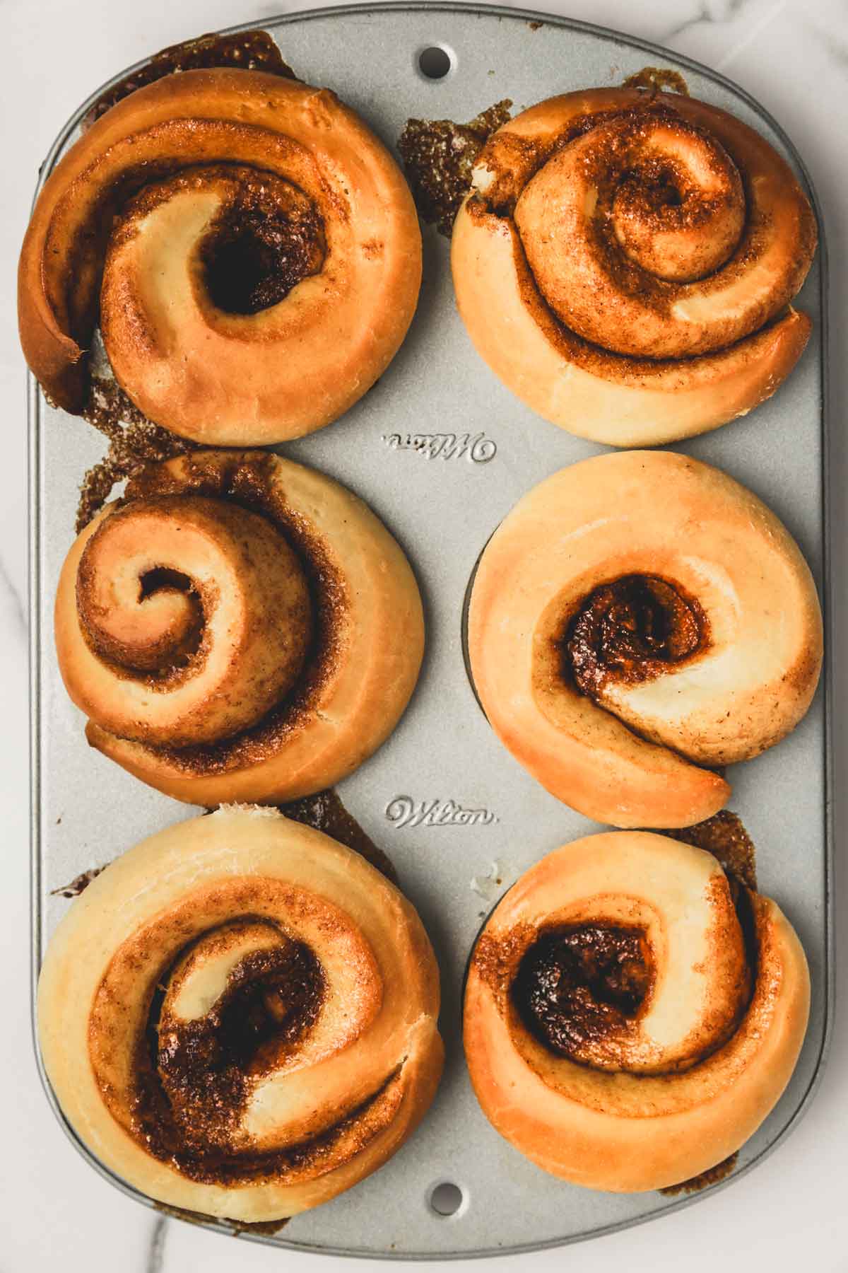 muffin pan with baked cinnamon rolls muffins