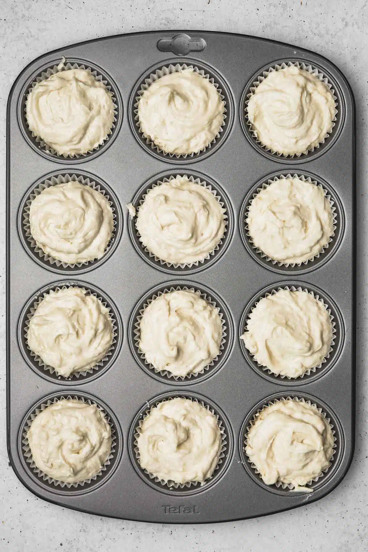 moule à cupcakes avec des caissettes remplies d'une pâte à muffins 