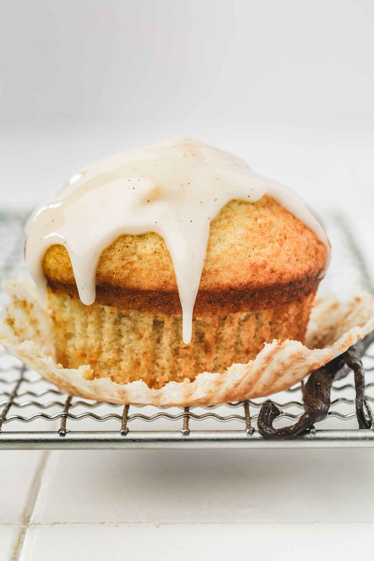 muffin in a wire rack with vanilla glaze