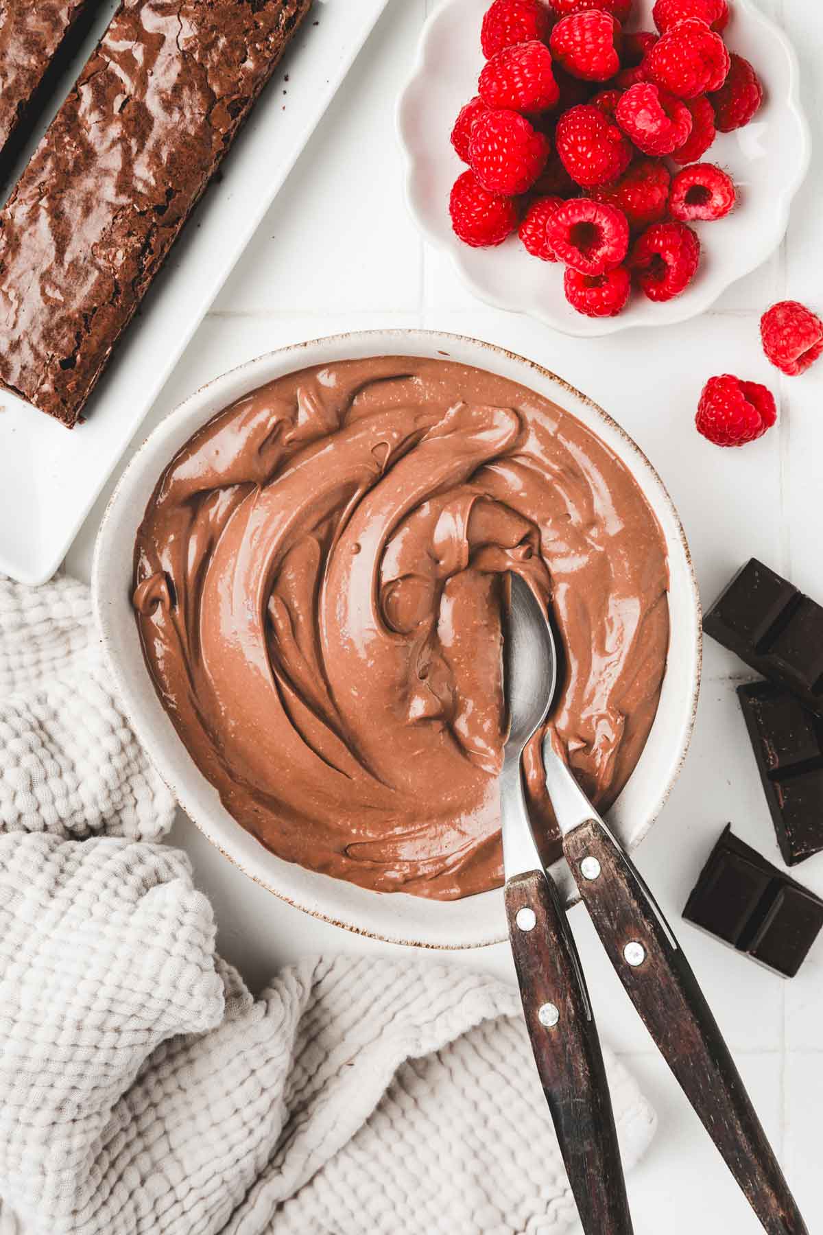 Bol sur une table avec du crémeux au chocolat et des cuillères 