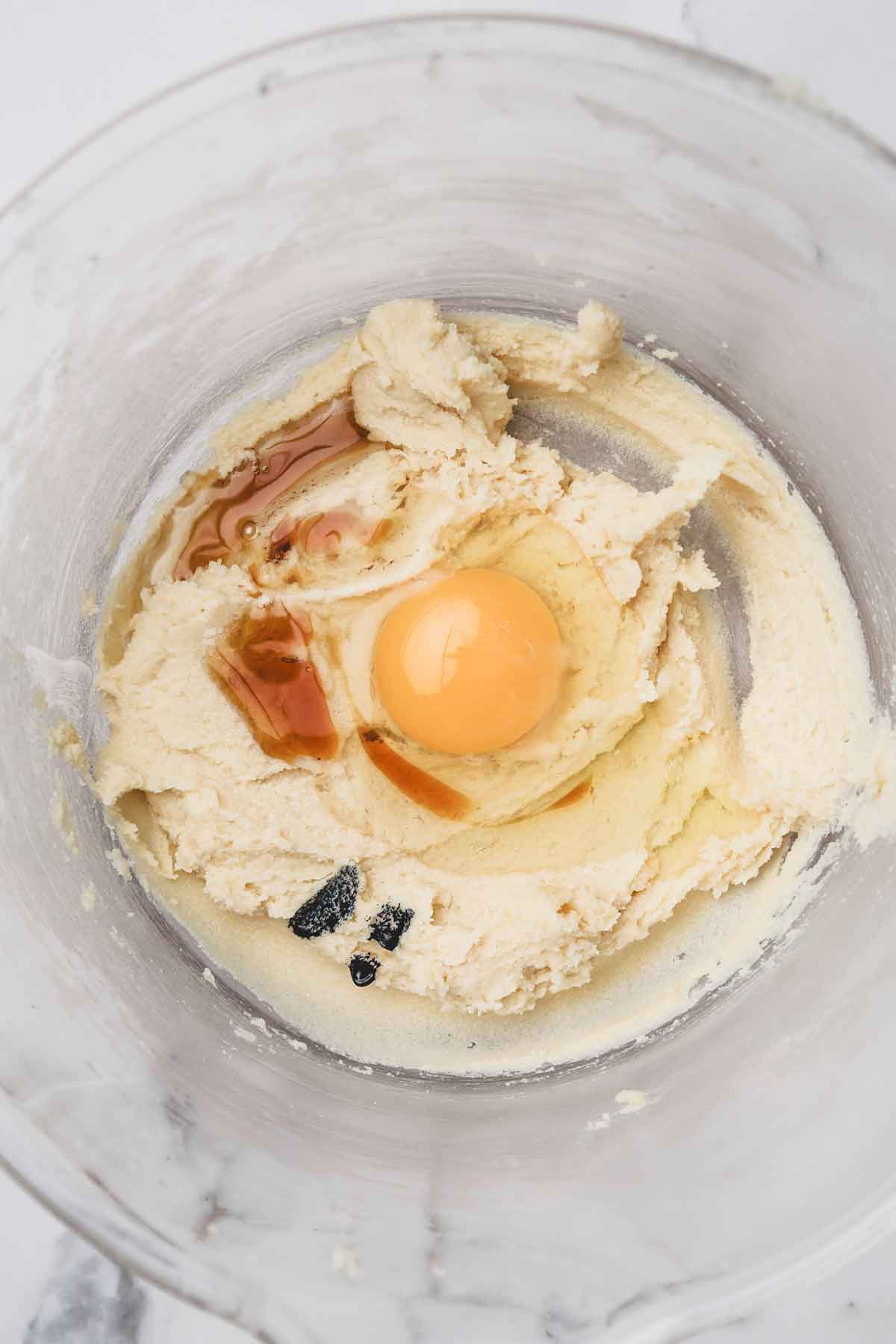 mixing bowl with creamed butter with egg vanilla and food coloring