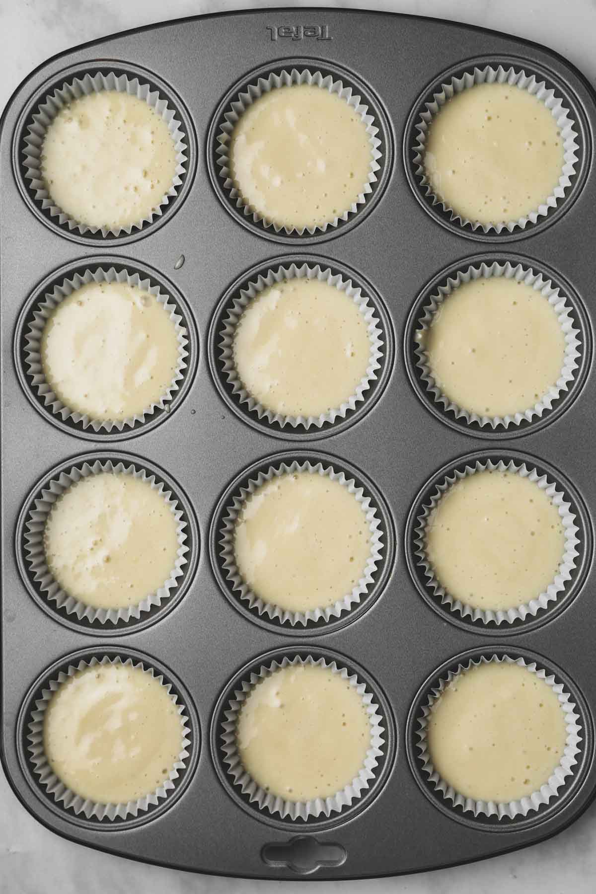 moule à cupcakes avec de la pâte à cupcake crue