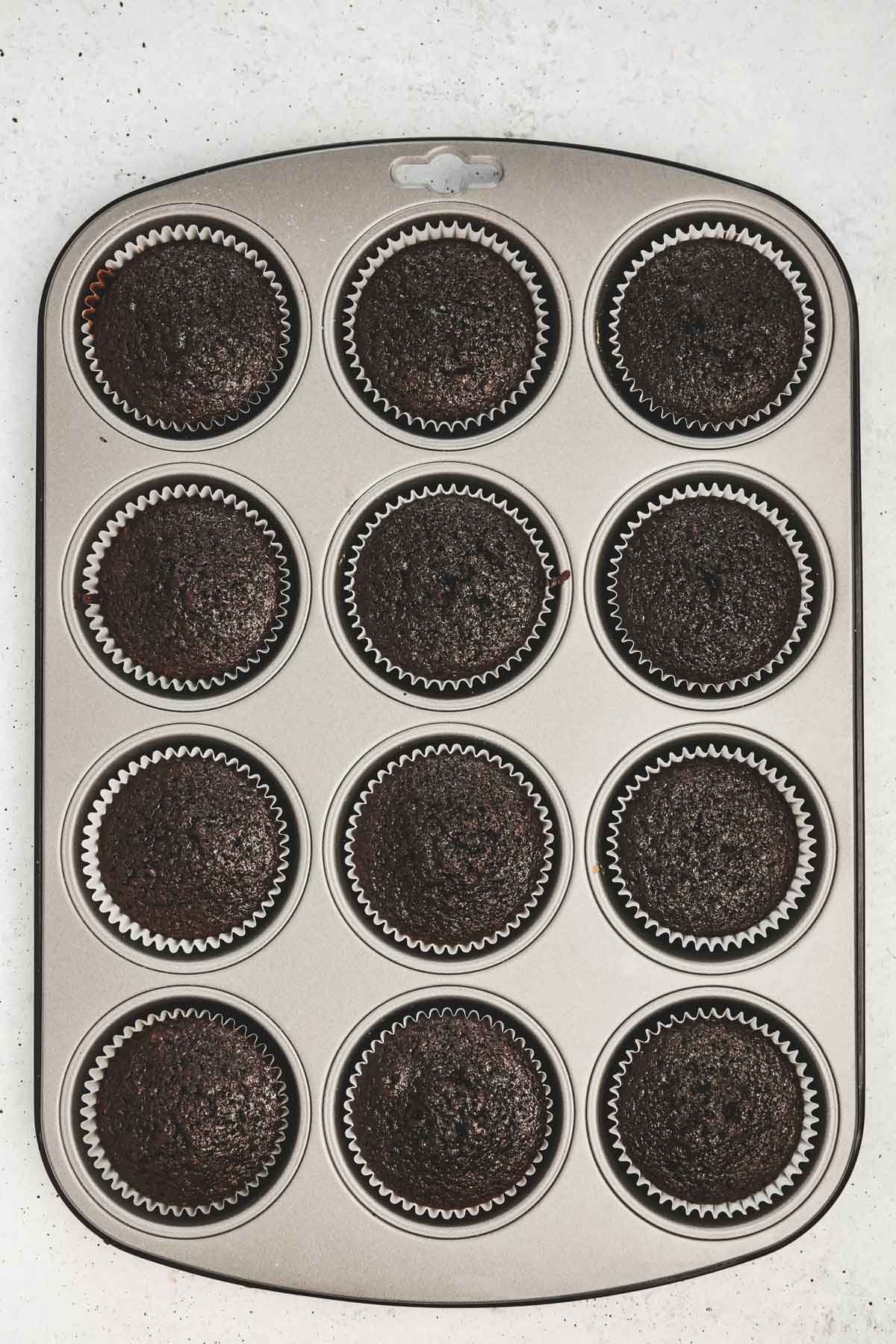 muffin pan with baked chocolate cupcakes