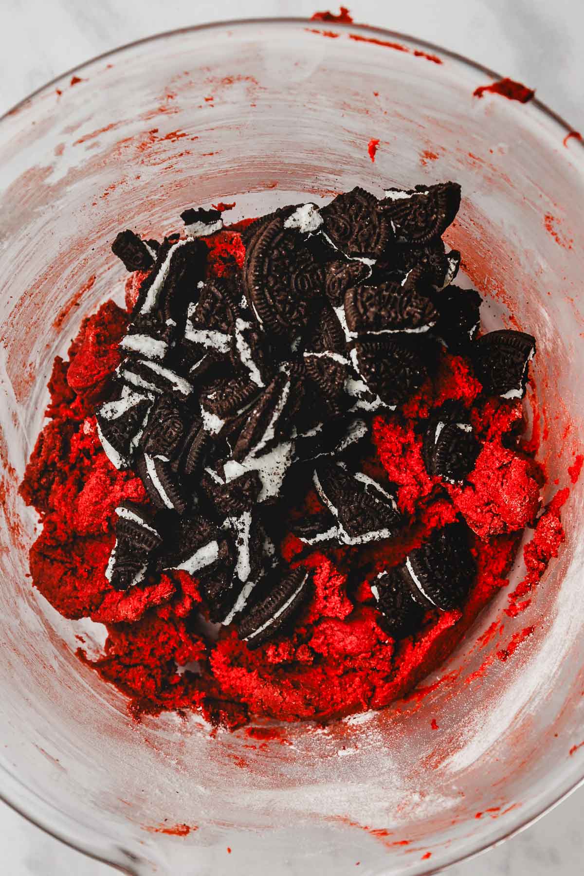 mixing bowl with red velvet cookie dough with crushed oreos