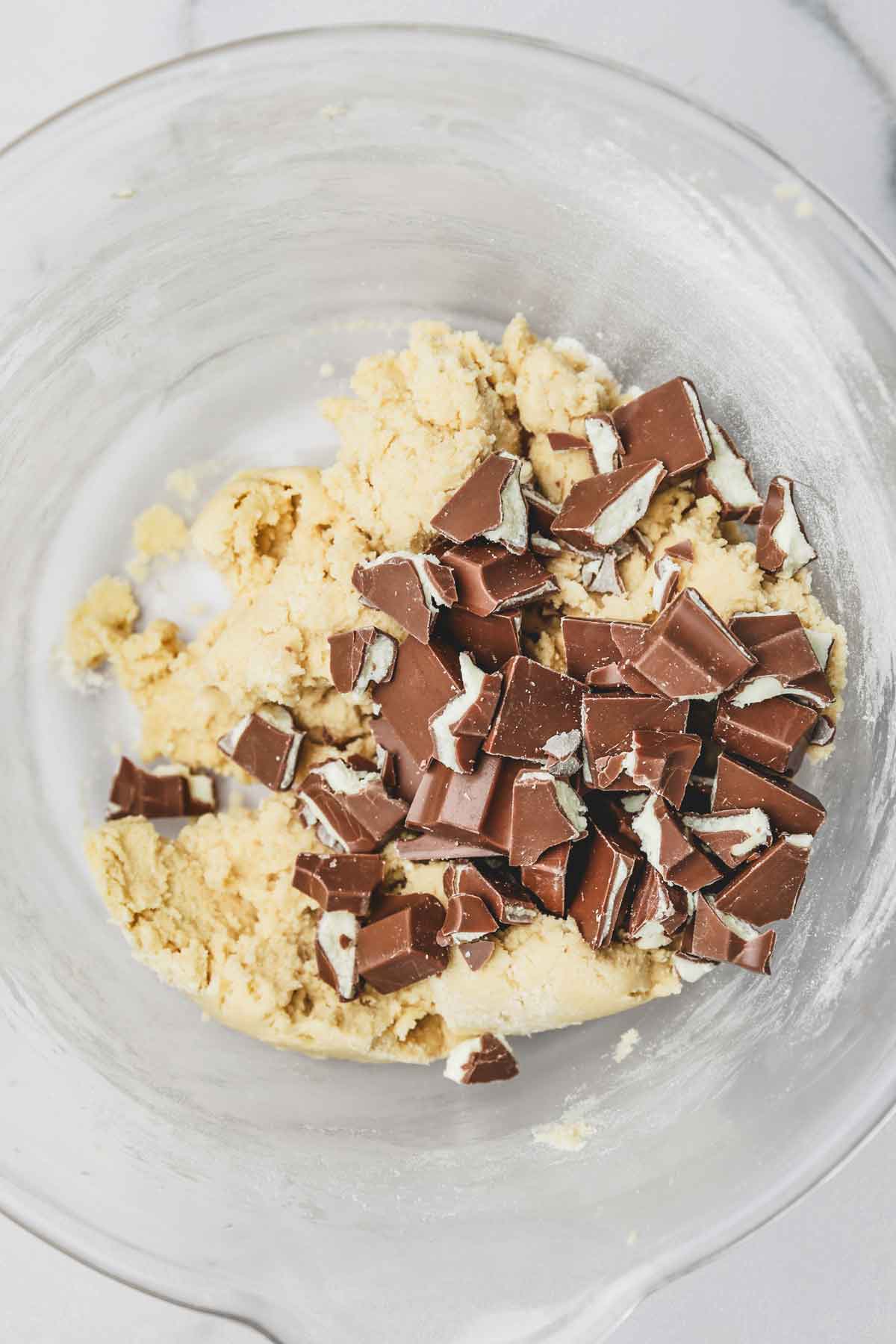 mixing bowl with cookie batter and chopped chocolate bars