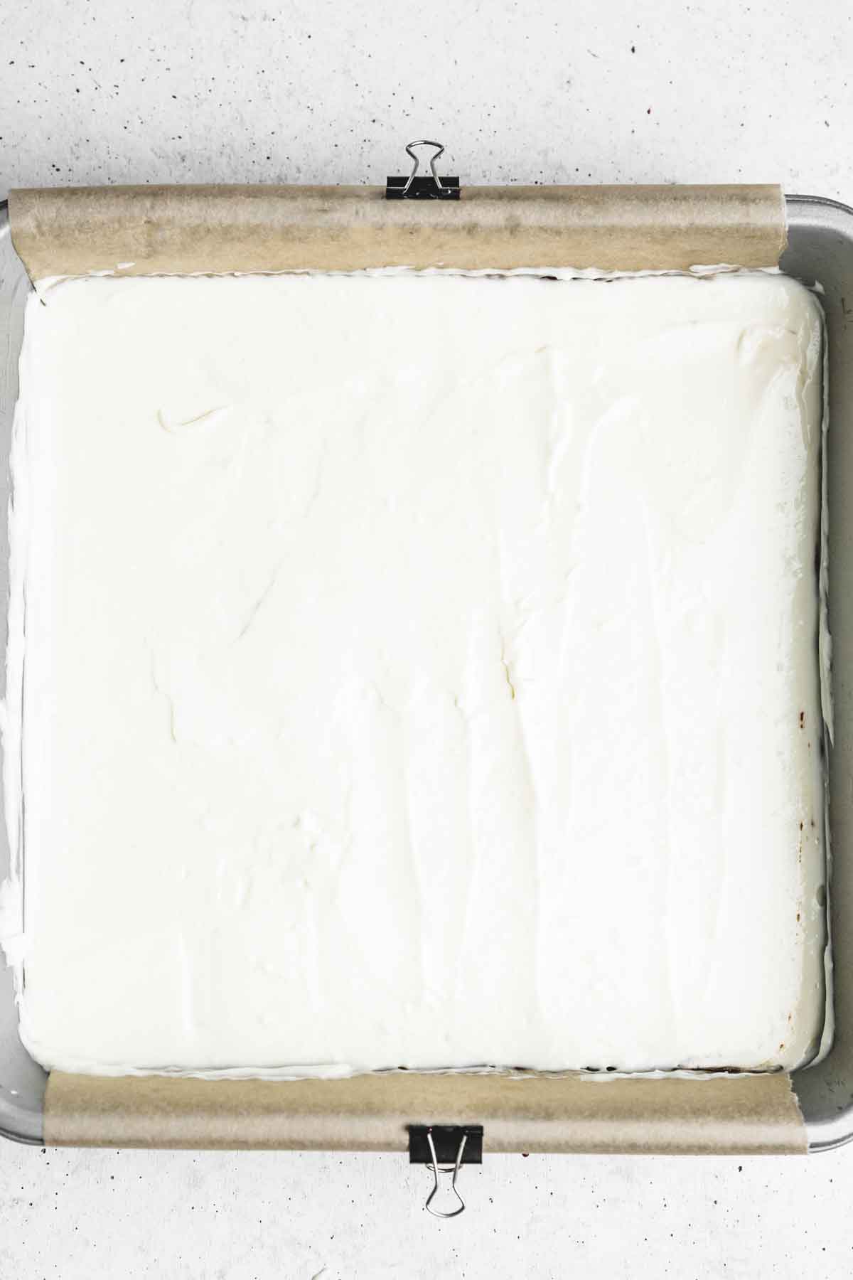 square cake pan with a layer of cream cheese mixture