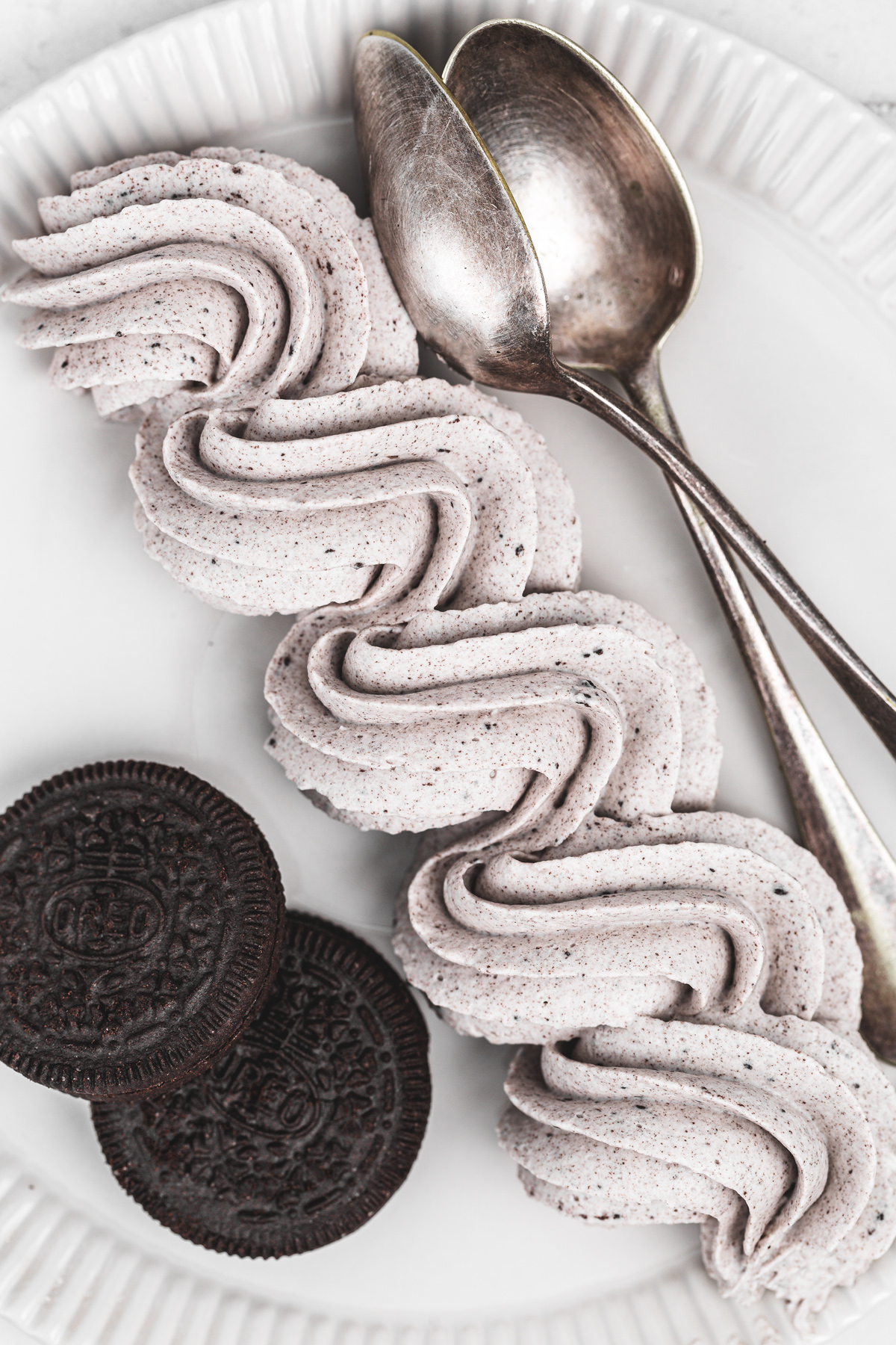 oreo cream cheese frosting piped on a plate with a smooth whipped texture