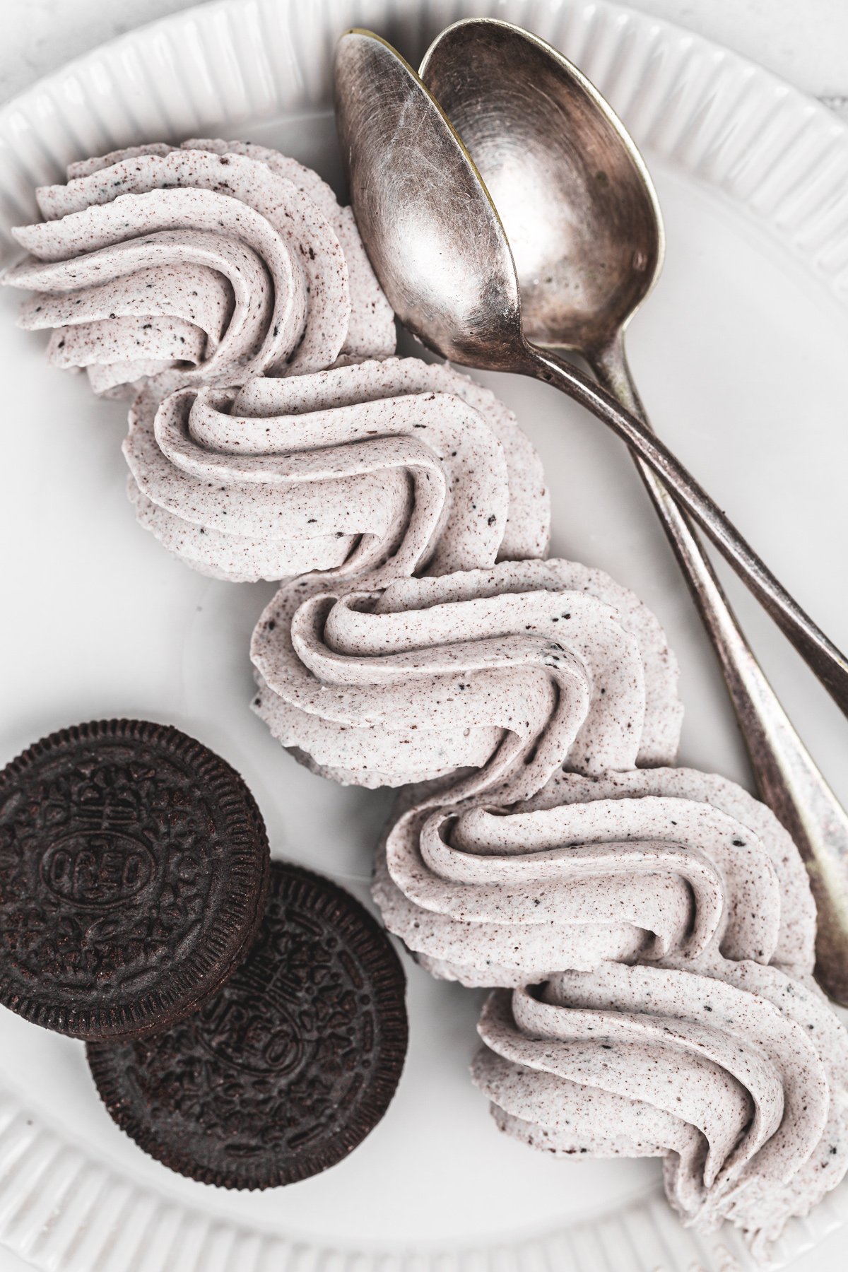 oreo cream cheese frosting piped on a plate with a smooth whipped texture