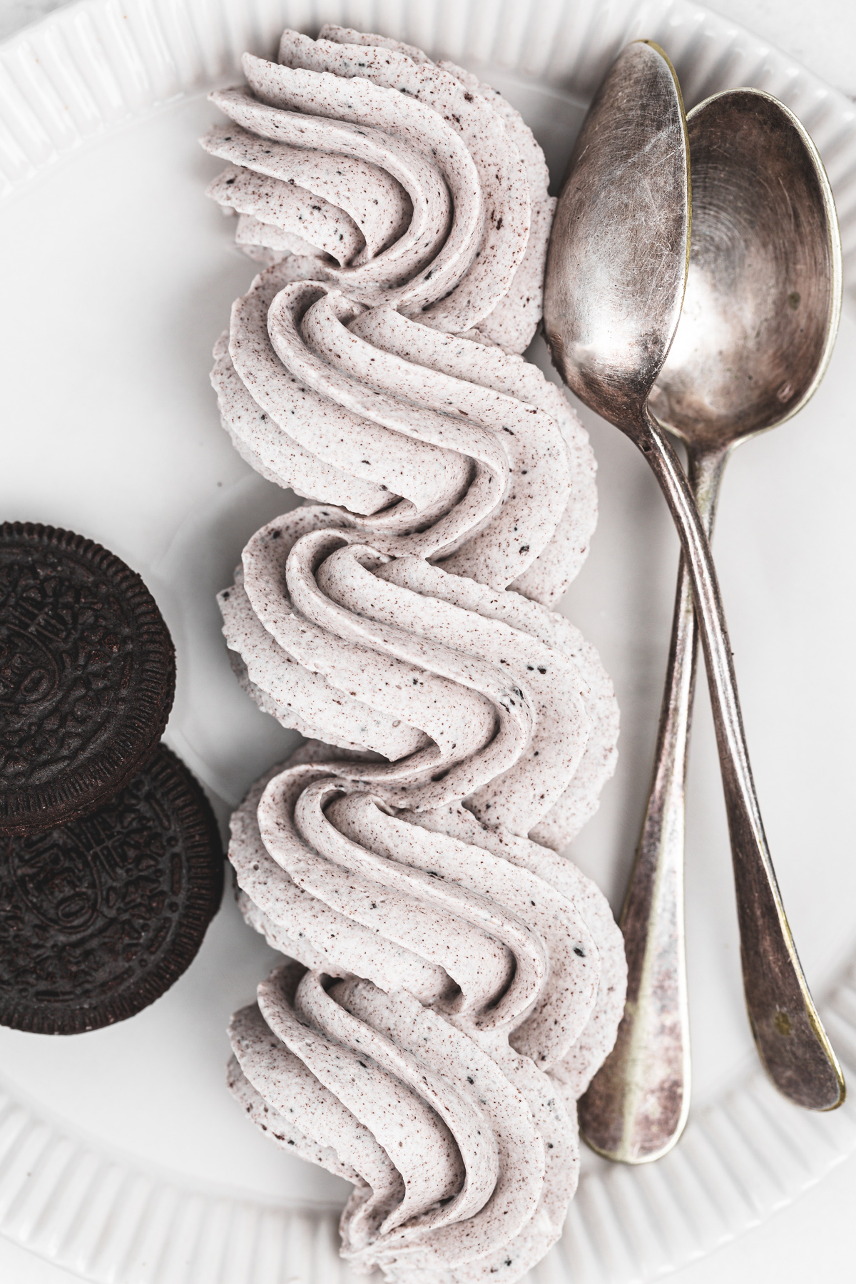 oreo cream cheese frosting served on a plate with a spoon ready to use