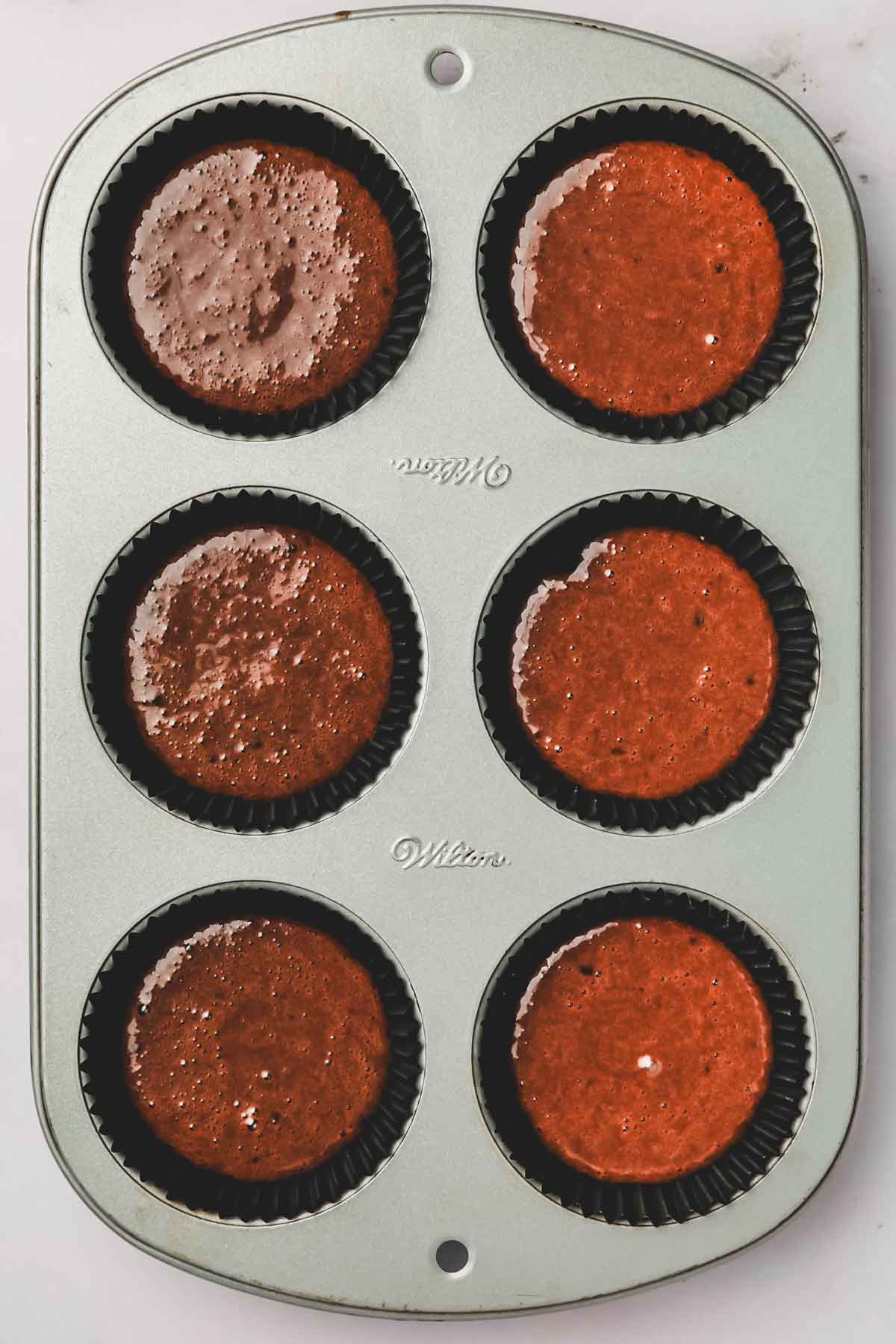 muffin pan with chocolate cupcake batter