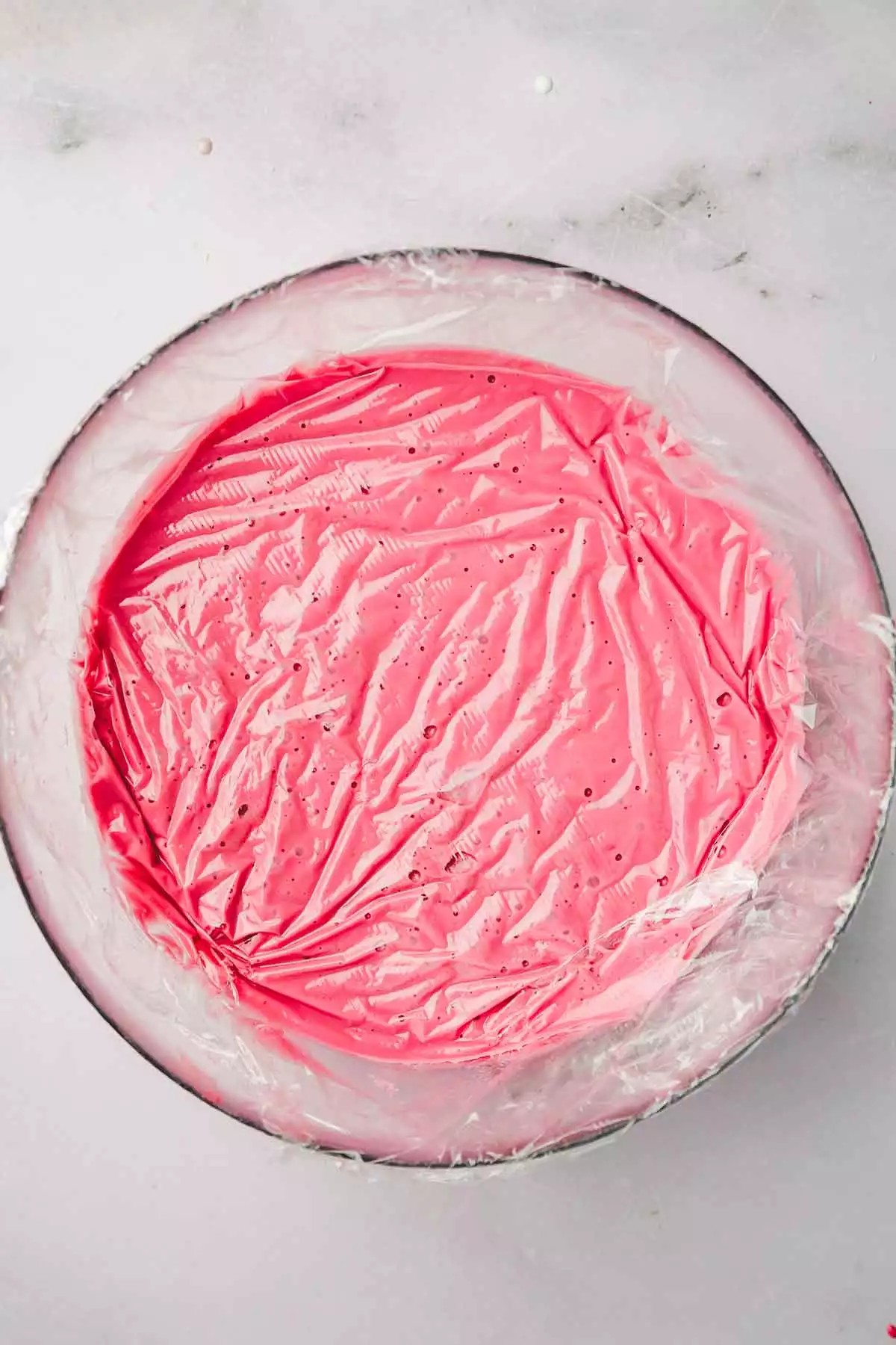 medium bowl with ping ganache under a cling film