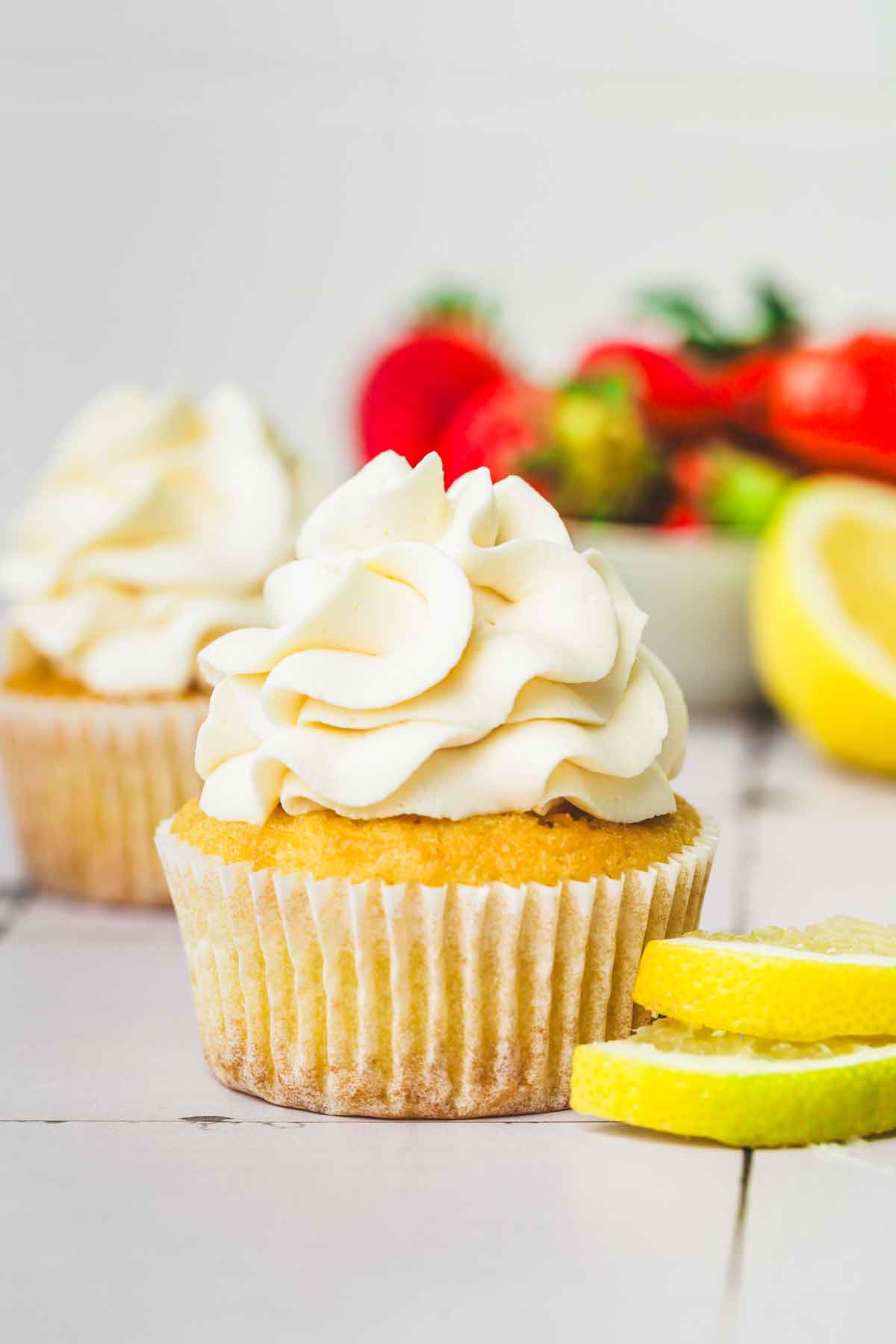 cupcakes topped with lemon cream cheese frosting on a table