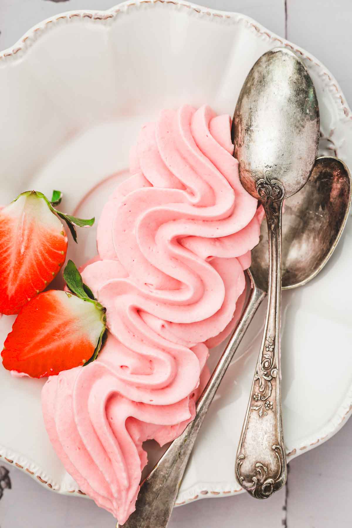 assiette avec du glaçage cream cheese fraise et des cuillères