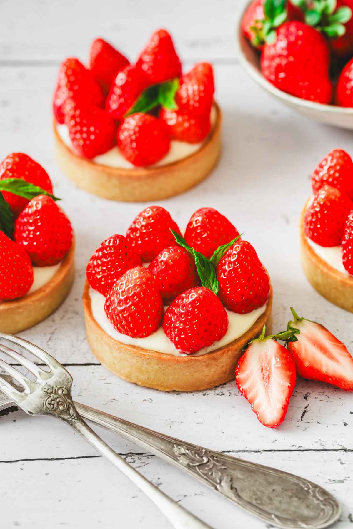 mini strawberry custard tartlets on a table
