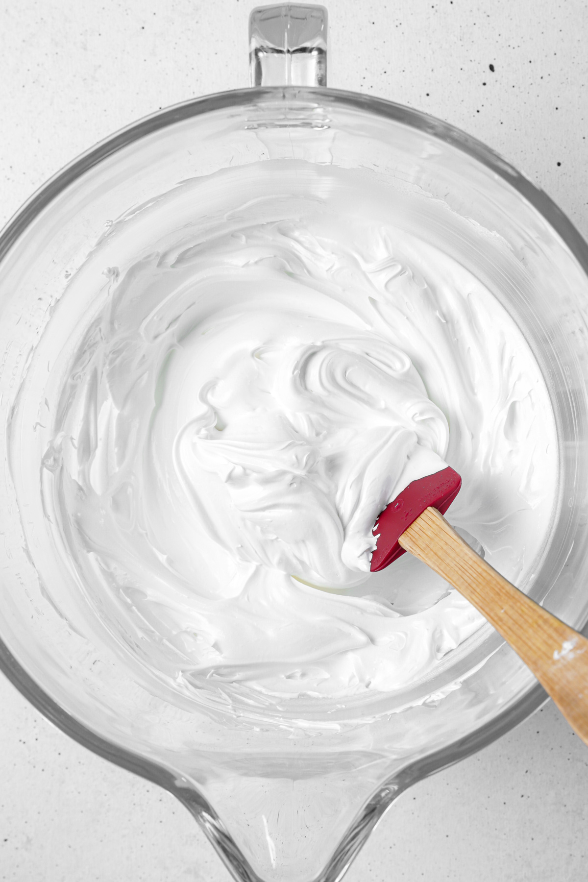 Bowl of fluffy Swiss meringue frosting with stiff peaks