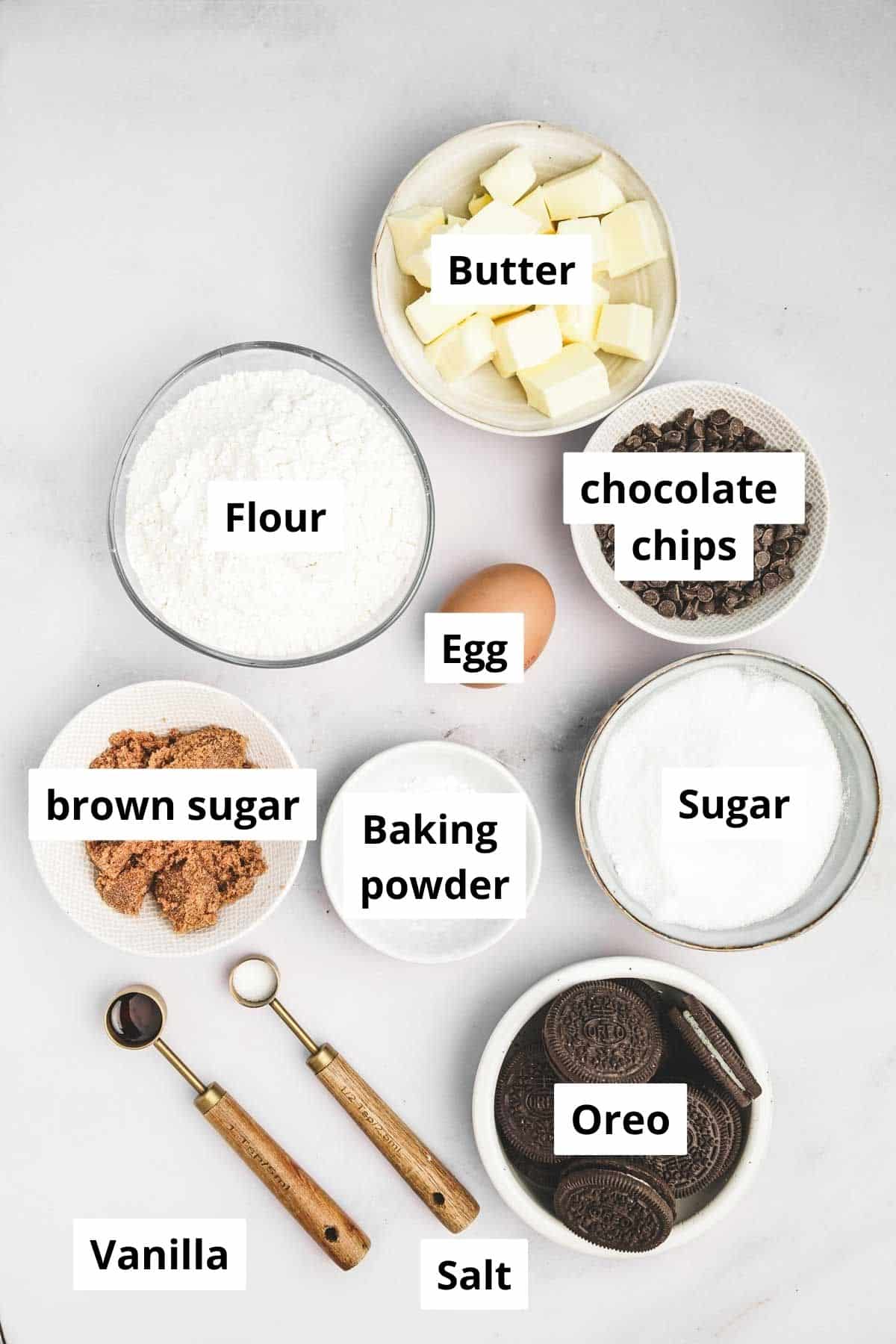 Bowls with ingredients for Oreo cookie brownies, including flour, sugar, cocoa powder, and eggs