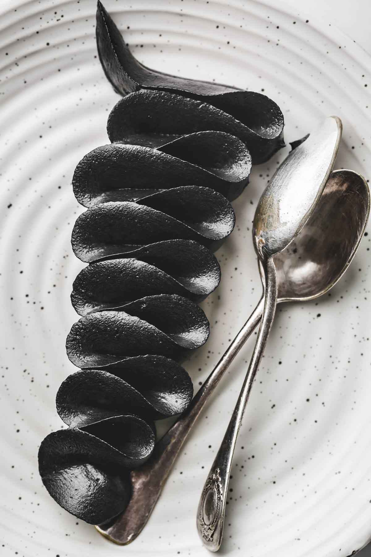 Crème au beurre noire pochée à la douille dans une assiette