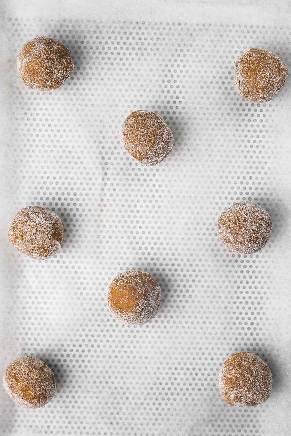 gingerbread cookie dough balls on a cookie sheet