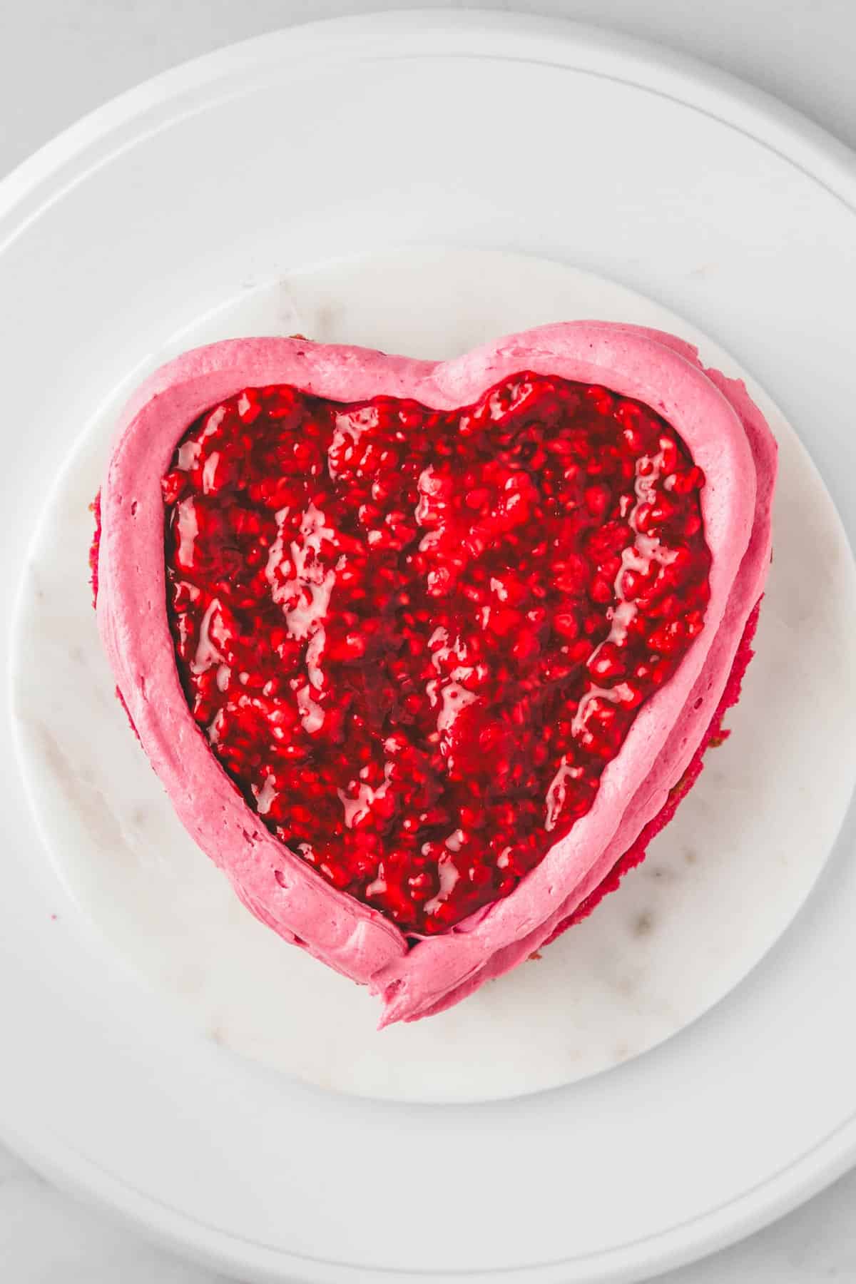 cake board with pink cake layer with raspberry filling