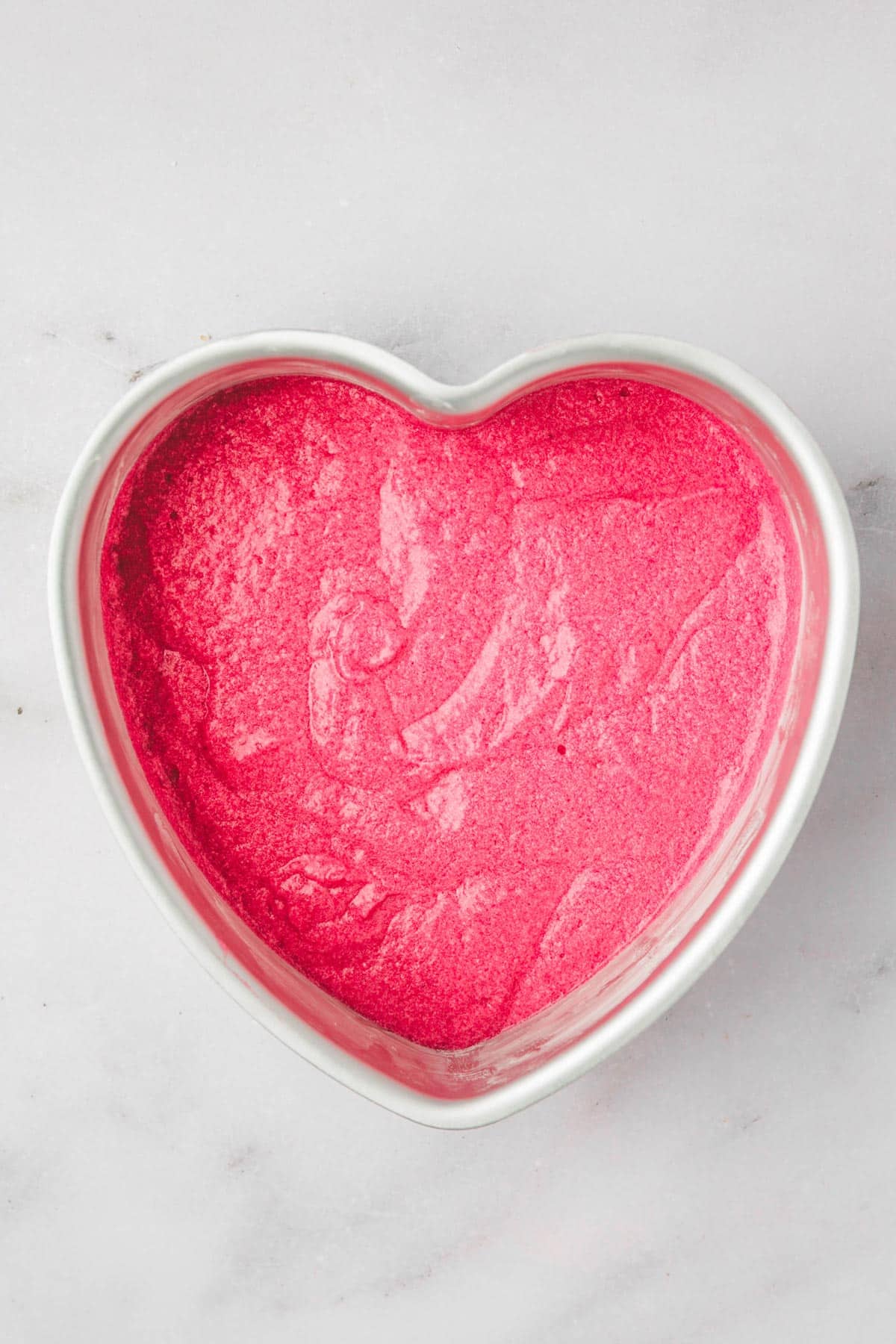 heart shaped cake pan with pink cake batter