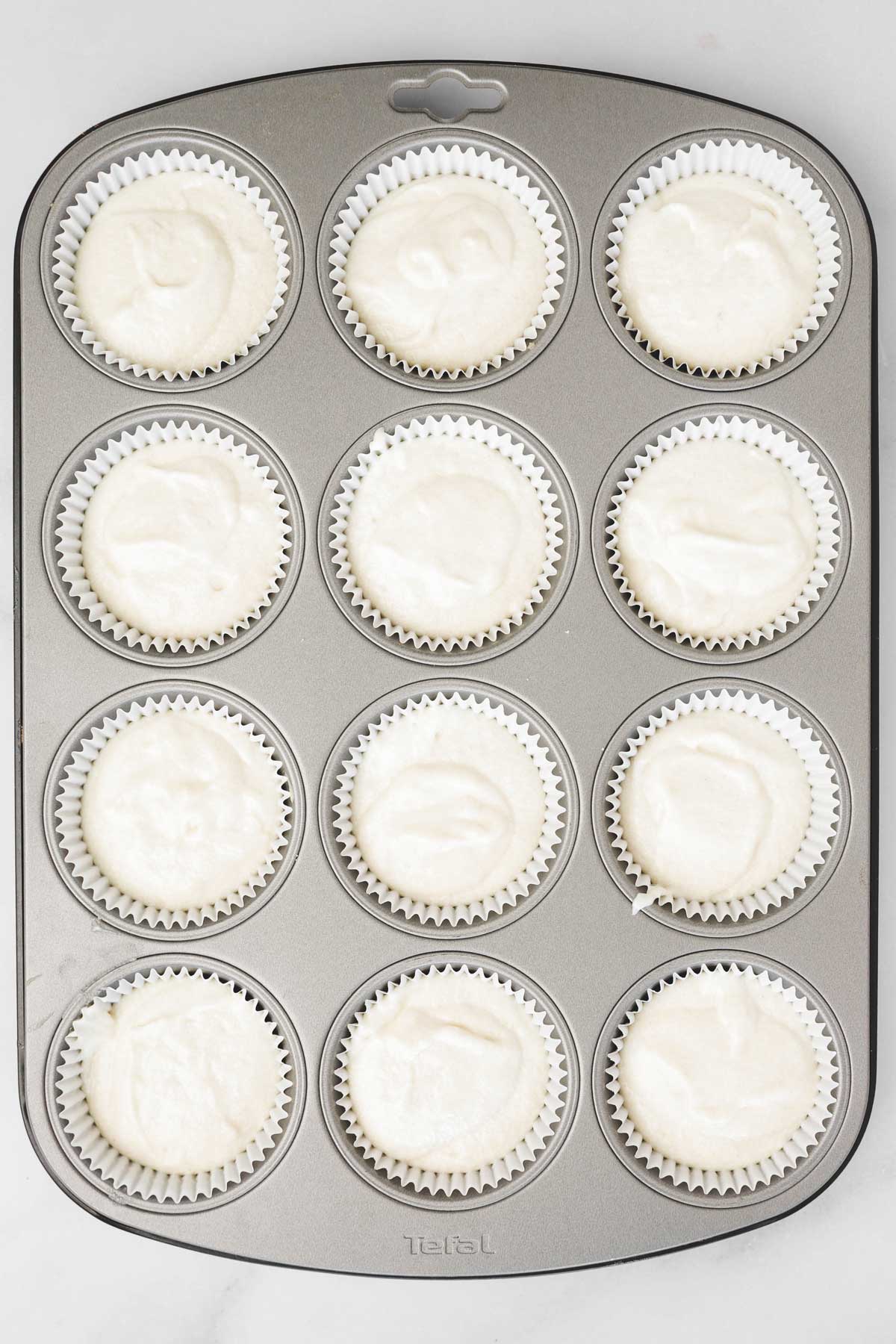 muffin pan with cupcakes batter