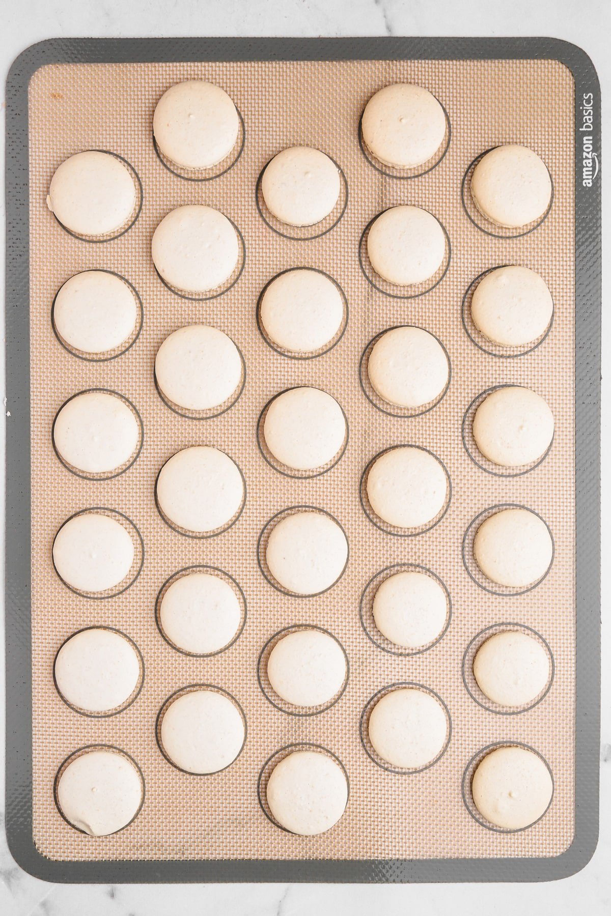 baked macaron shell on a silicon macaron mat
