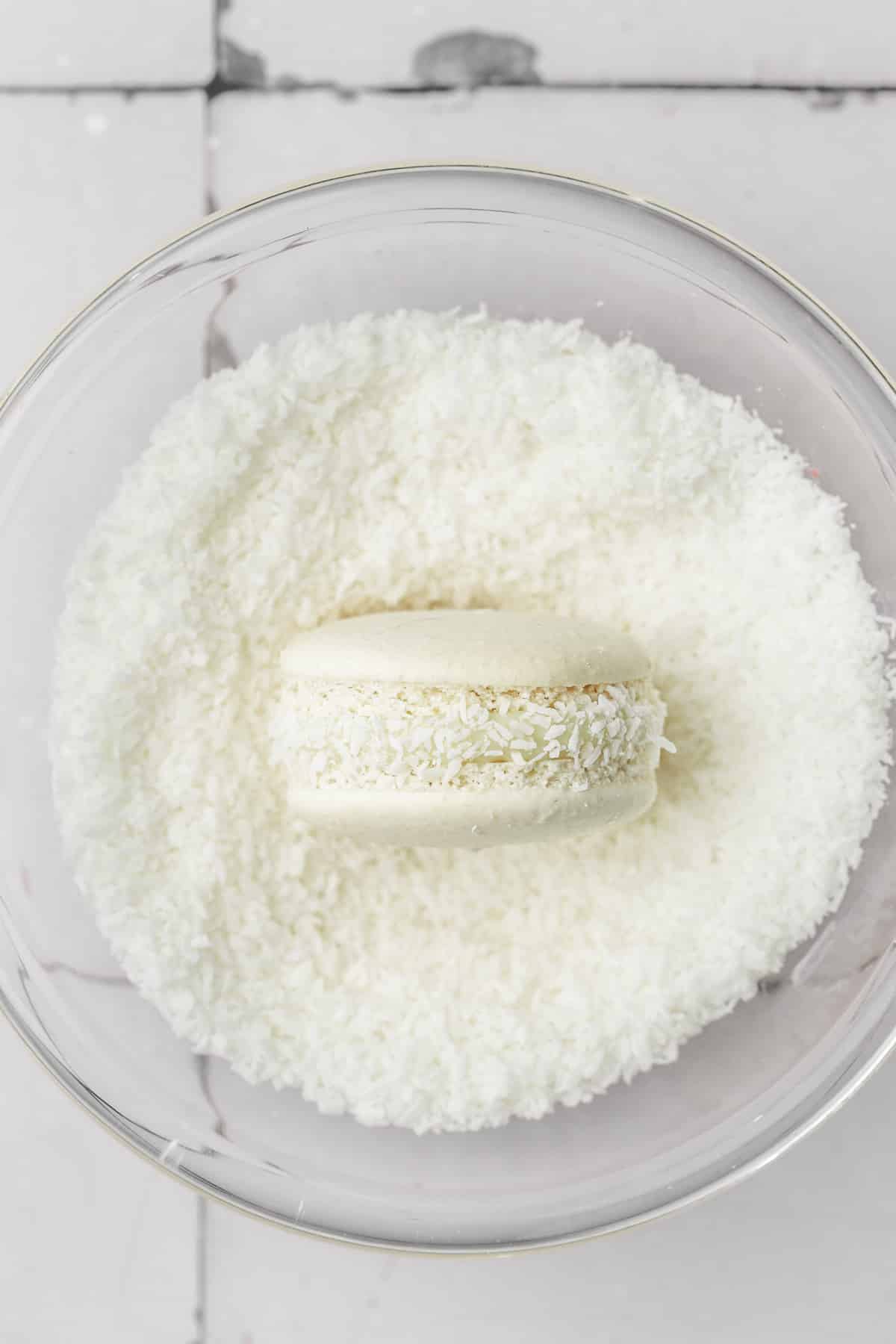 medium bowl with shredde coconut and one coconut macaron