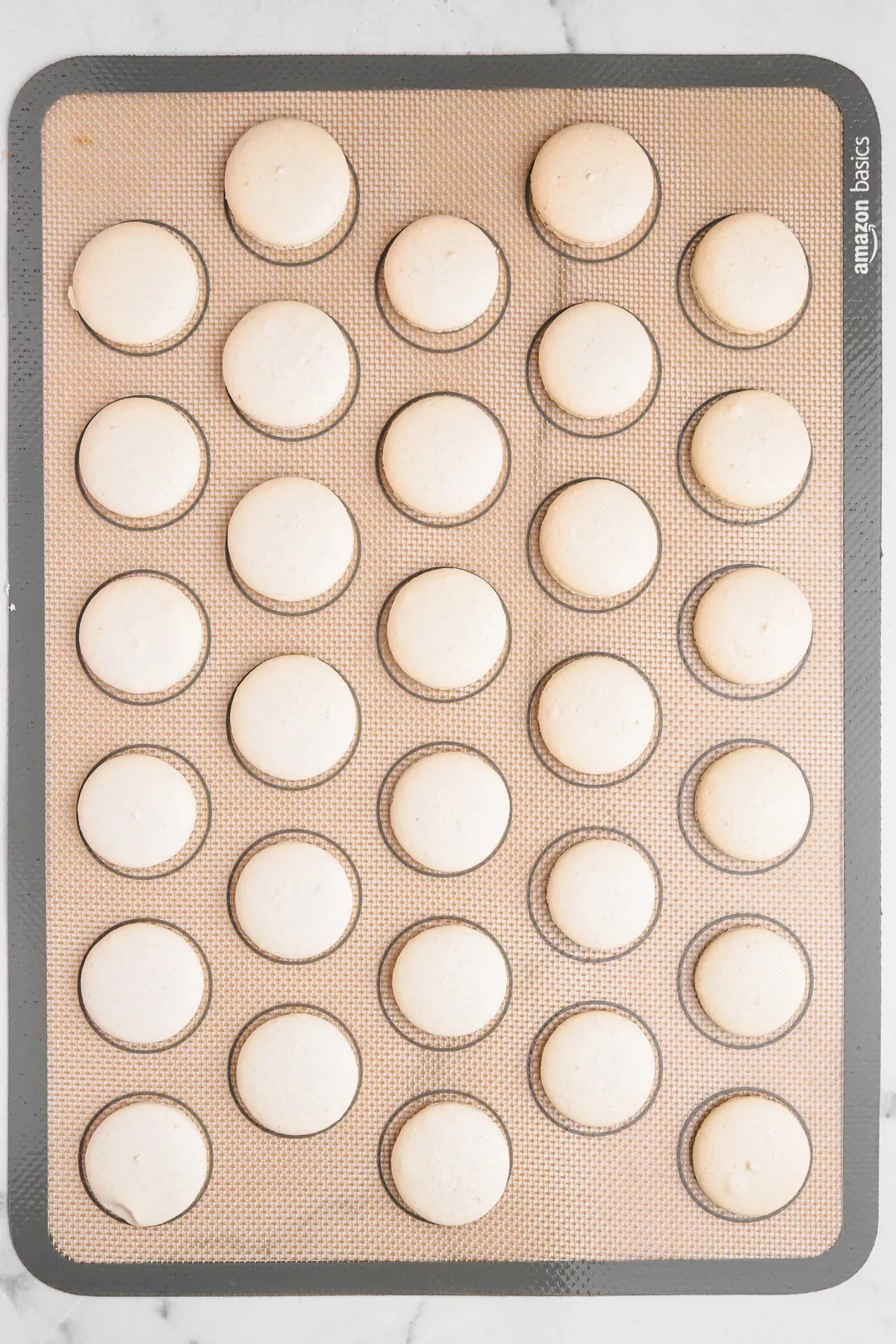 baked macaron shell on a silicon macaron mat