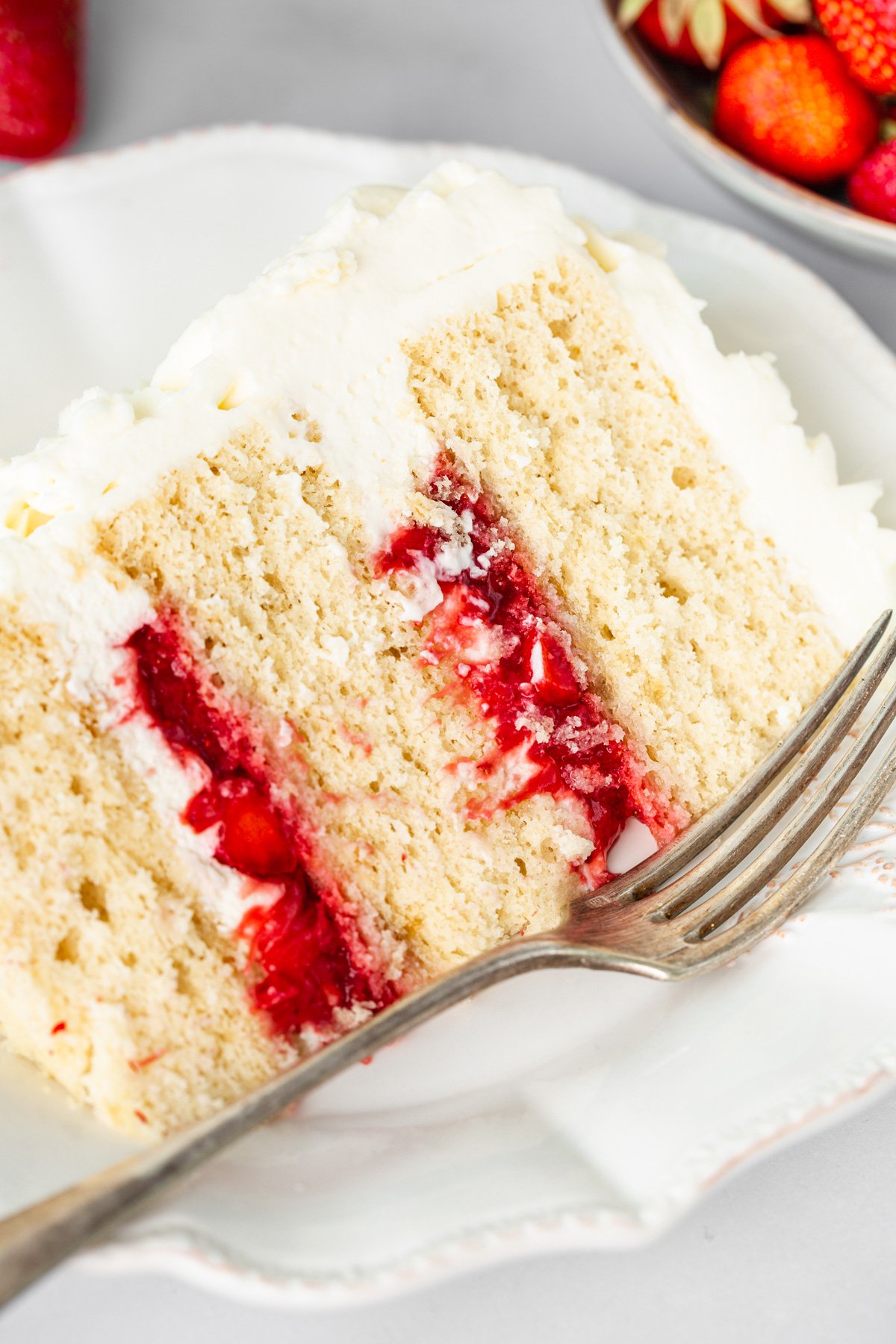 part de layer cake fraise vanille mascarpone sur une assiette