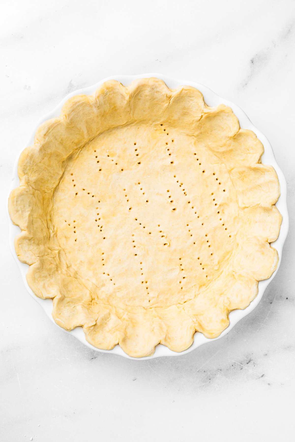 Moule à tarte garni de pâte prête à cuire pour une tarte au citron meringuée