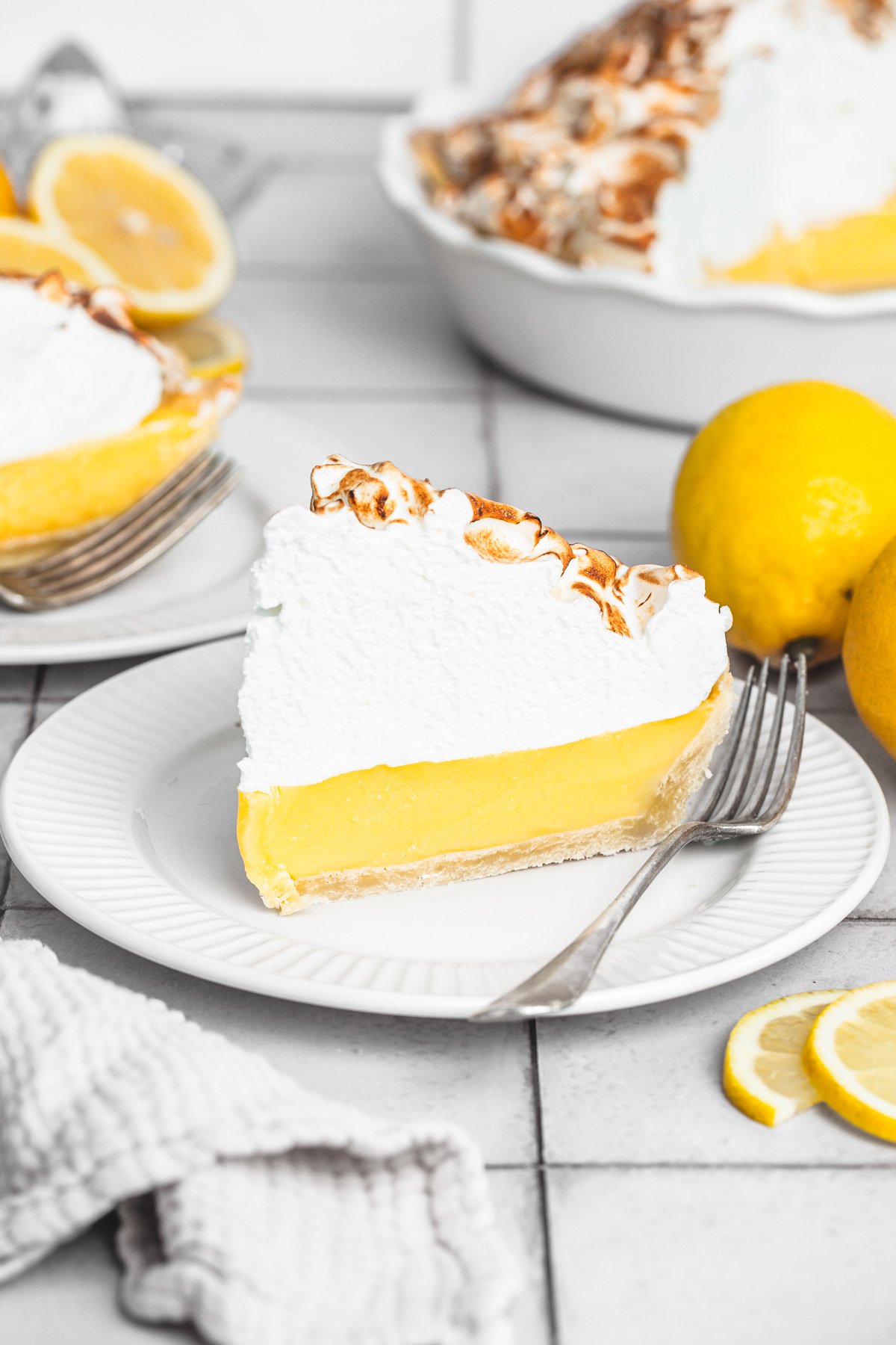Part individuelle de tarte au citron meringuée servie dans une assiette à dessert