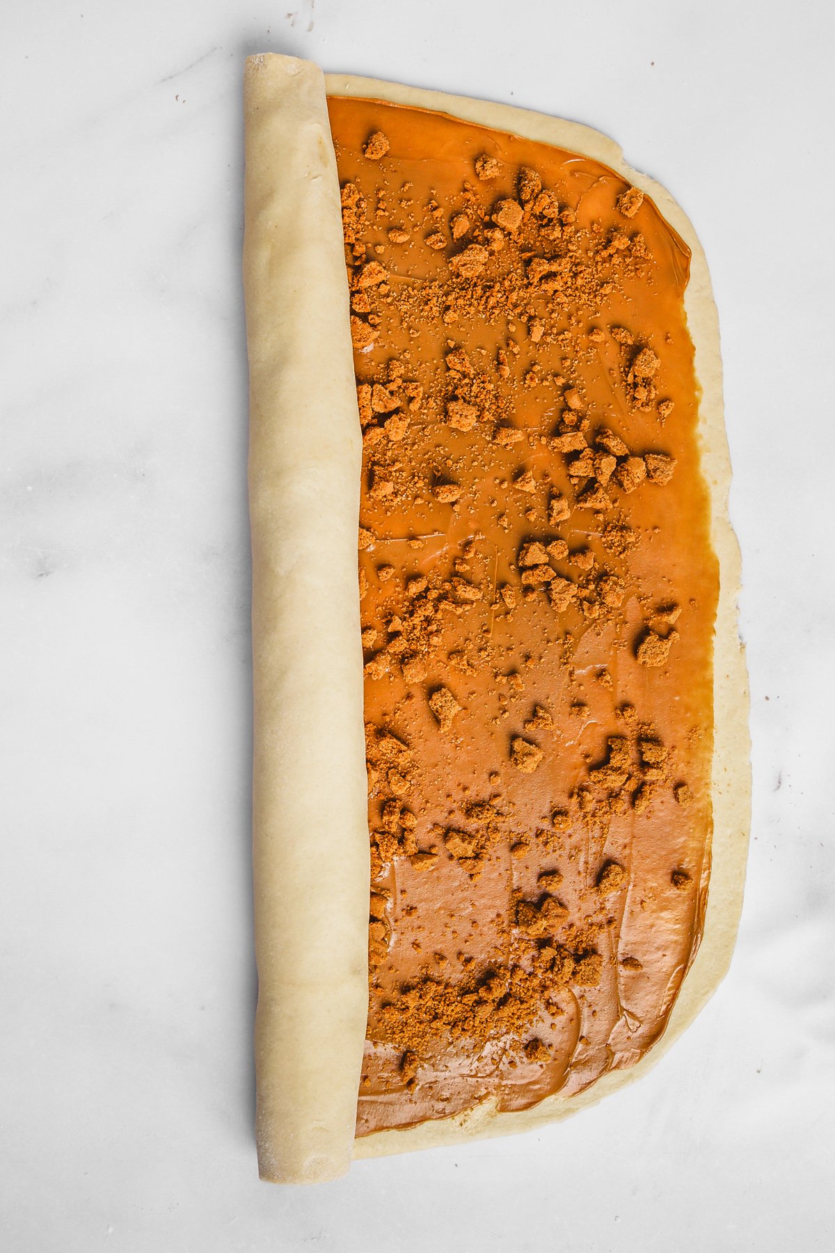 Dough rolled tightly to form Biscoff cinnamon rolls