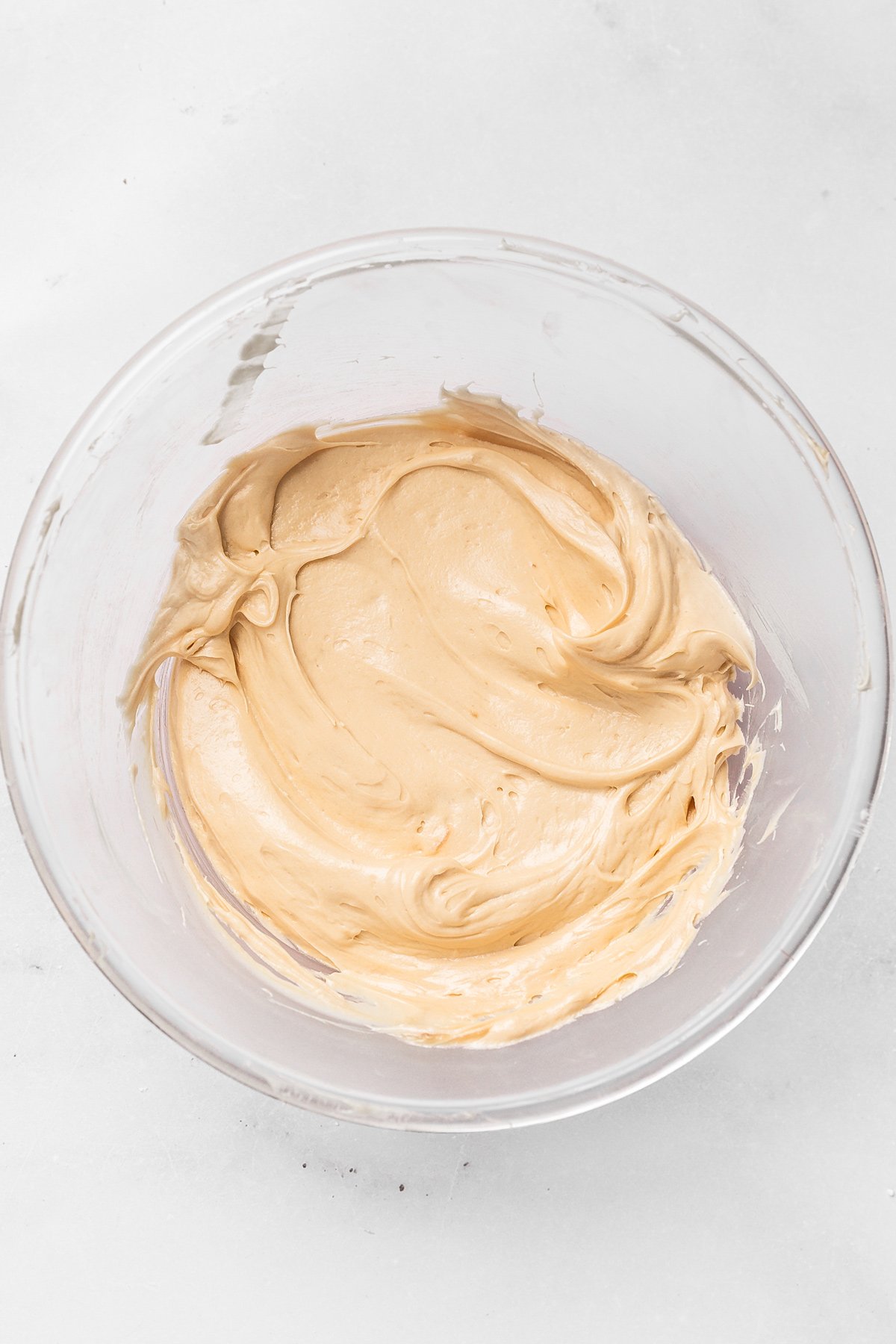 Bowl with creamy Biscoff cream cheese frosting ready to spread